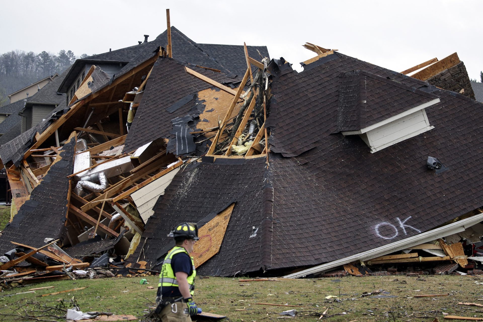 A firefighter surveys damage to a house after a tornado touches down south of Birmingham in the Eagle Point community damaging multiple homes Thursday March 25, 2021.