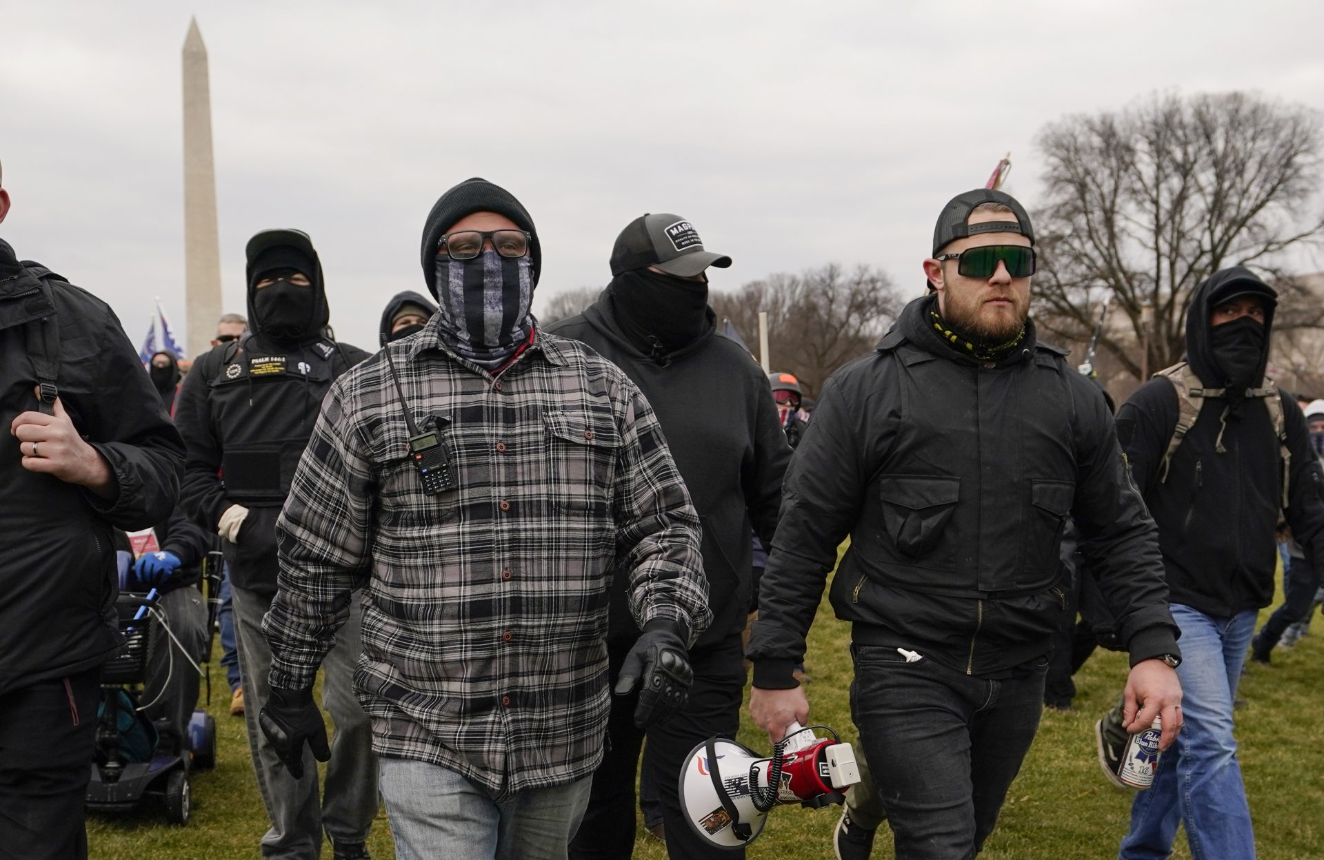 In this Jan. 6, 2021, photo, Proud Boy members Joseph Biggs, left, and Ethan Nordean, right with megaphone, walk toward the U.S. Capitol in Washington, in support of President Donald Trump. The Proud Boys and Oath Keepers make up a fraction of the more than 300 Trump supporters charged so far in the siege that led to Trump's second impeachment and resulted in the deaths of five people, including a police officer. But several of their leaders, members and associates have become the central targets of the Justice Department’s sprawling investigation.