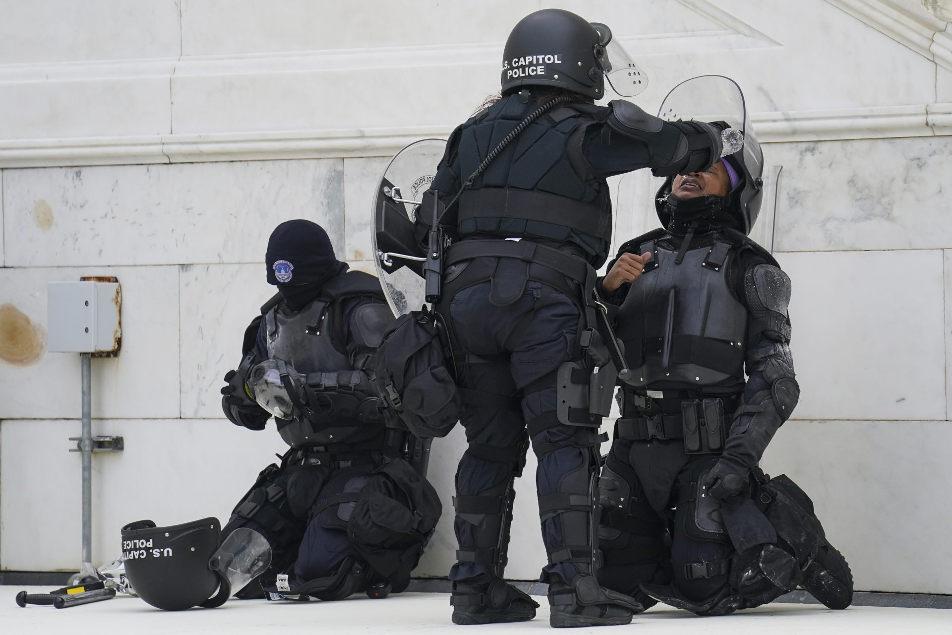 In this Jan. 6, 2021, file photo a police officer has eyes flushed with water after a confrontation with rioters at the Capitol in Washington.