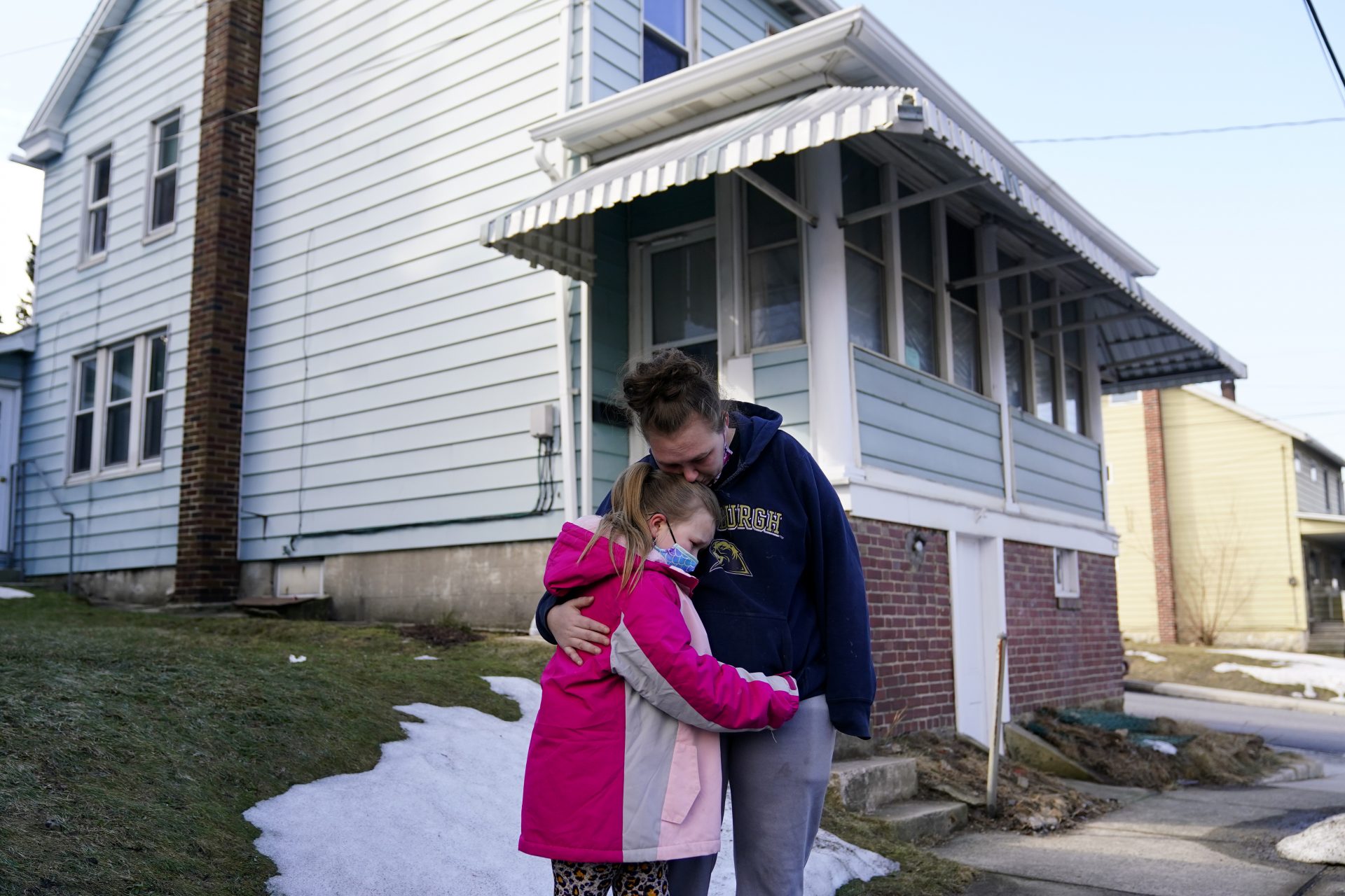 Melissa Weirich, right, hugs her daughter, Kacie Thompson, 9, outside the former home of her friend, Ava Lerario, Thursday, March 11, 2021, in Lansford, Pa. On May 26, 2020, Ava; her mother, Ashley Belson, and Ava's father, Marc Lerario were found fatally shot inside the home.