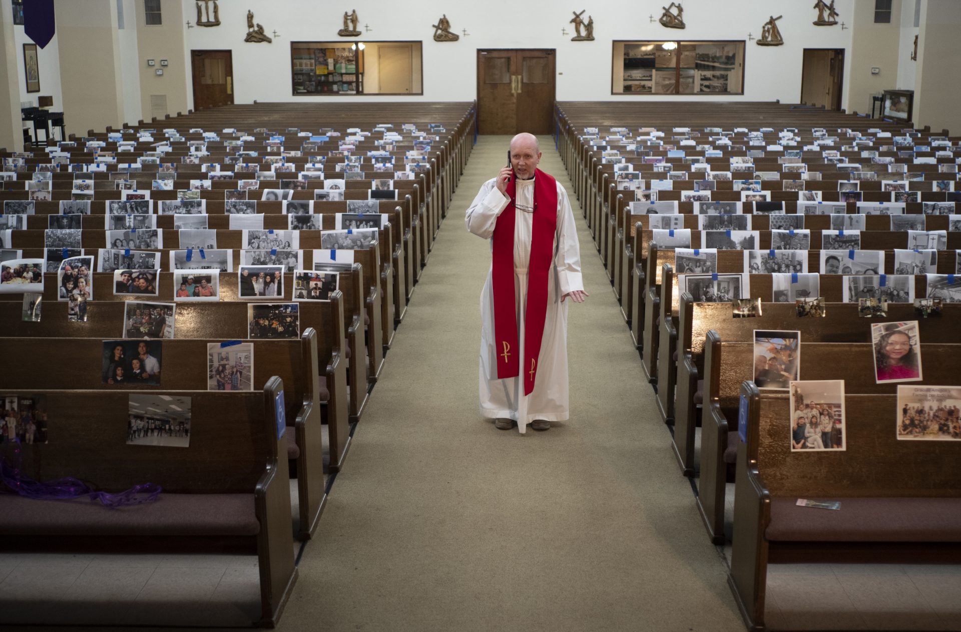 In this Friday, April 10, 2020 file photo, the Rev. Nicolas Sanchez takes a phone call from a parishioner after live-streaming the Good Friday Mass at St. Patrick's Catholic Church in Los Angeles.