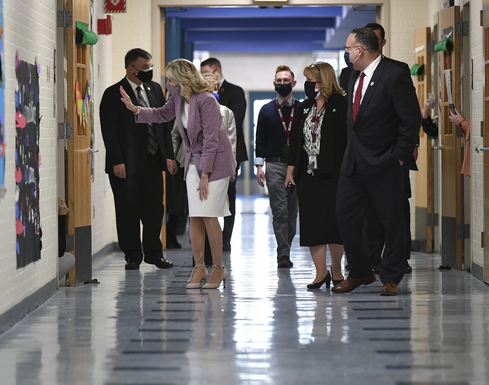 In this March 3, 2021, file photo waves to students in a classroom as she tours Benjamin Franklin Elementary School with Education Secretary Miguel Cardona, right, in Meriden, Ct.