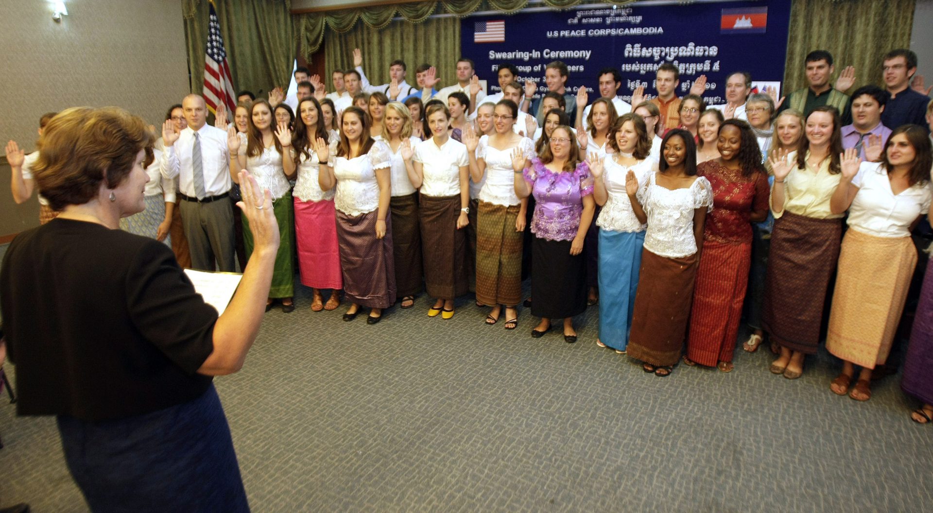 U.S. Peace Corps volunteers raise their hands to swear in during a ceremony in Phnom Penh, Cambodia, on Monday, Oct. 3, 2011. More than 100 Peace Corps volunteers on Monday held the swearing-in ceremony before joining Cambodian villagers in the southern provinces of Cambodia. 