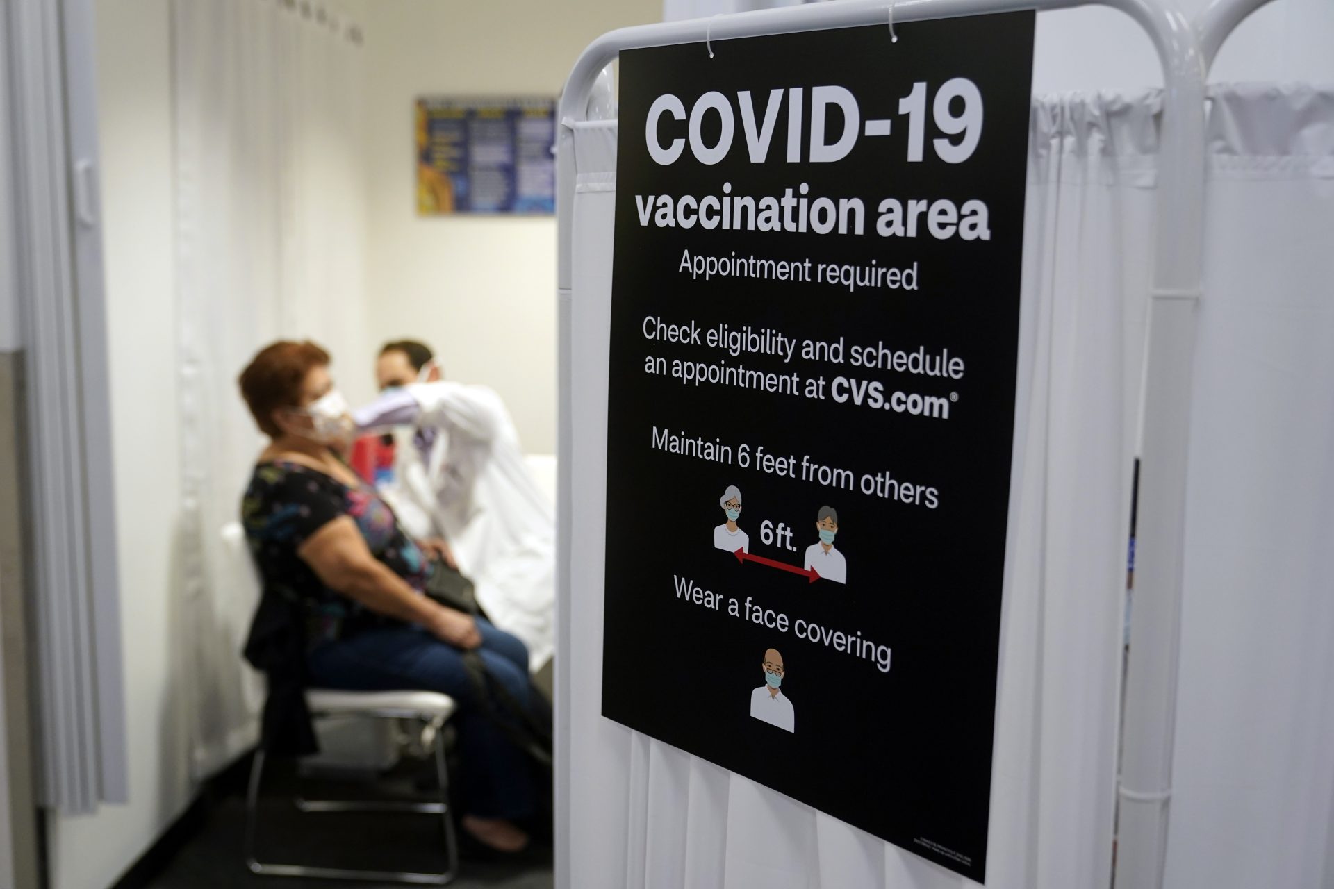- In this March 1, 2021, file photo, a patient receives a shot of the Moderna COVID-19 vaccine next to a guidelines sign at a CVS Pharmacy branch in Los Angeles.