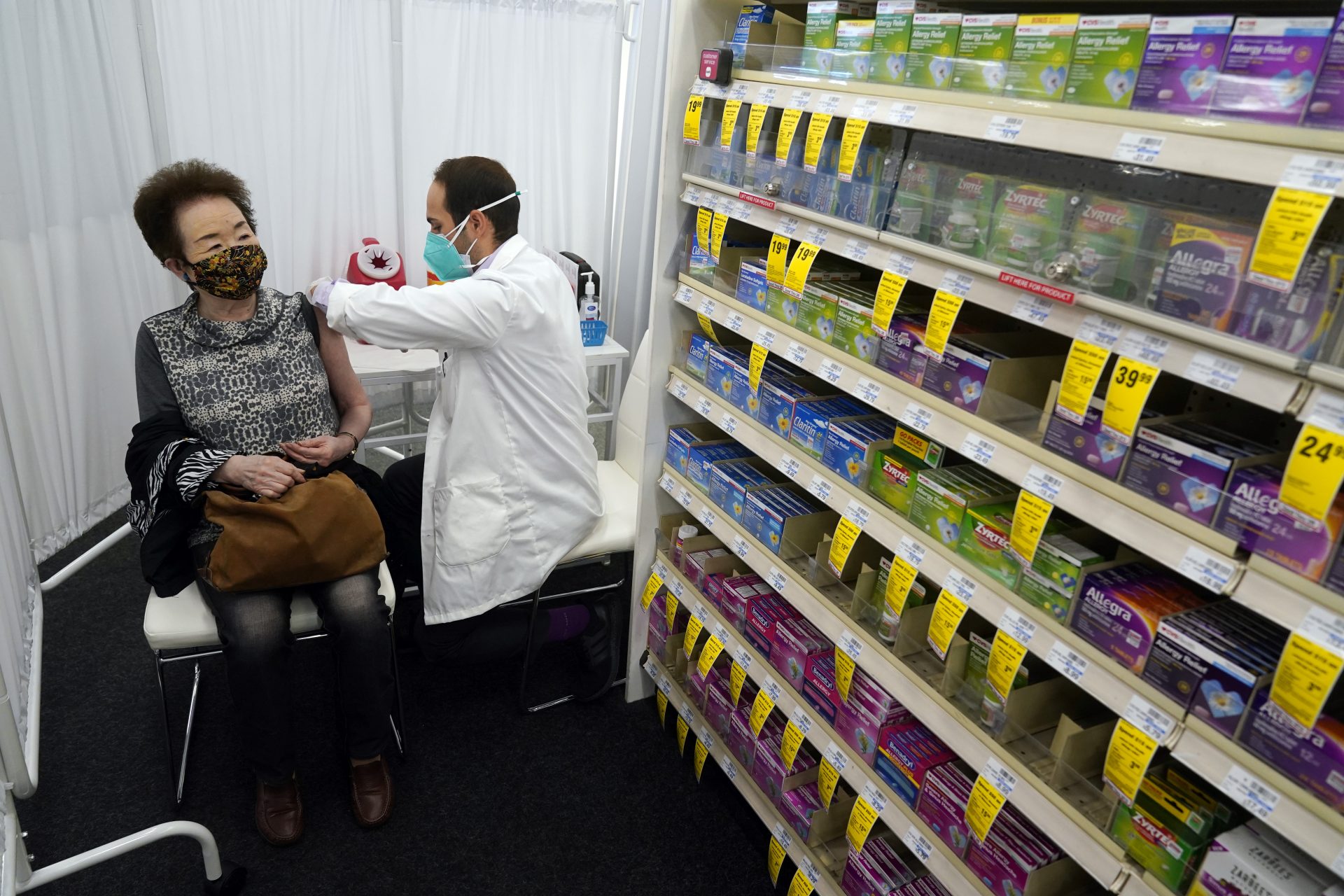Farmacistul Todd Gharibian, dreapta, administrează o doză de vaccin Moderna COVID-19 lui Toshiko Sugiyama, stânga, la o sucursală a farmaciei CVS luni, 1 martie 2021, din Los Angeles.