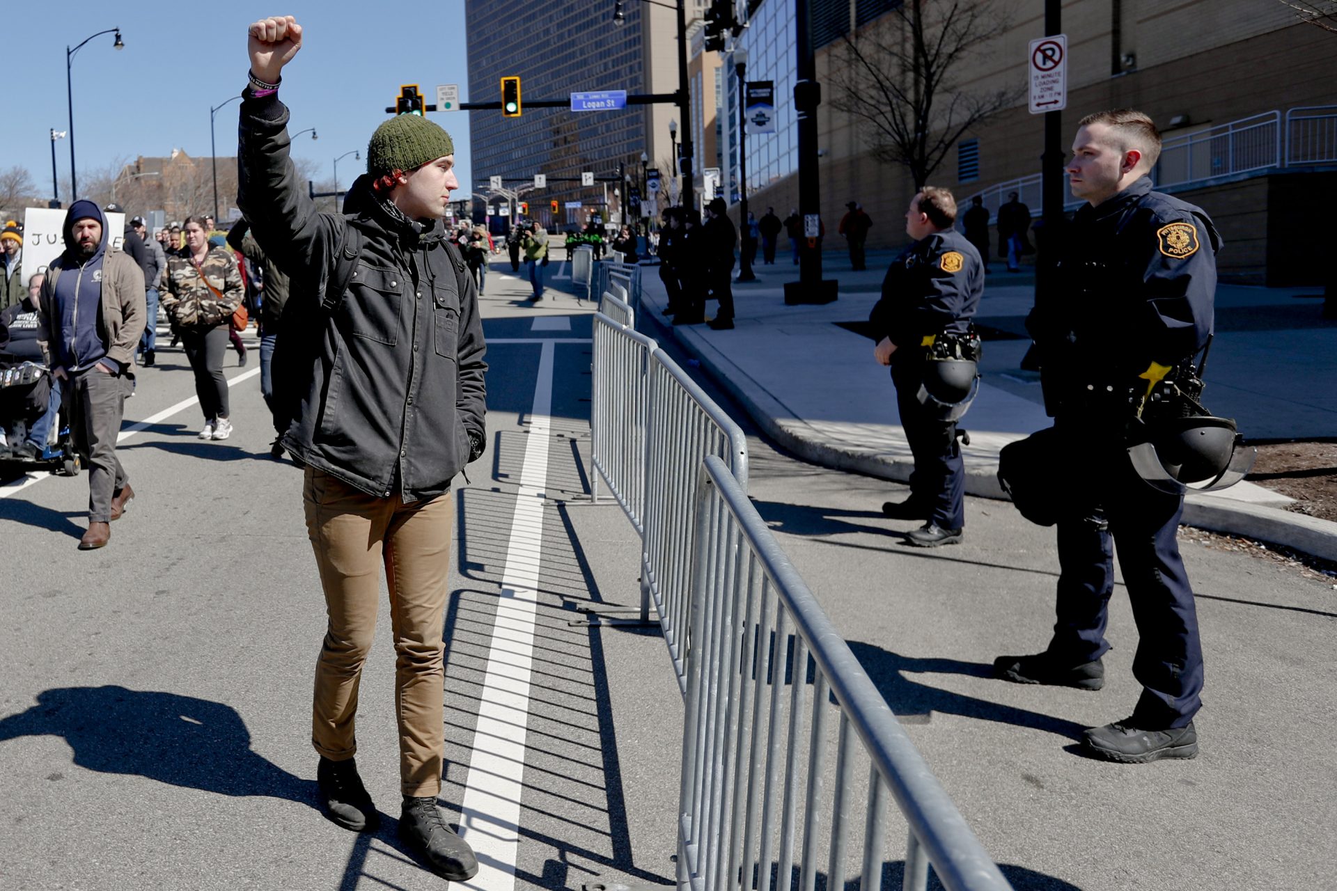 In this March 23, 2019 file photo, a marcher holds up his fist while staring at police lined up in front of PPG Paints Arena in Pittsburgh during a protest after a former suburban police officer was acquitted of a homicide charge in the on-duty shooting death of Antwon Rose II in East Pittsburgh.