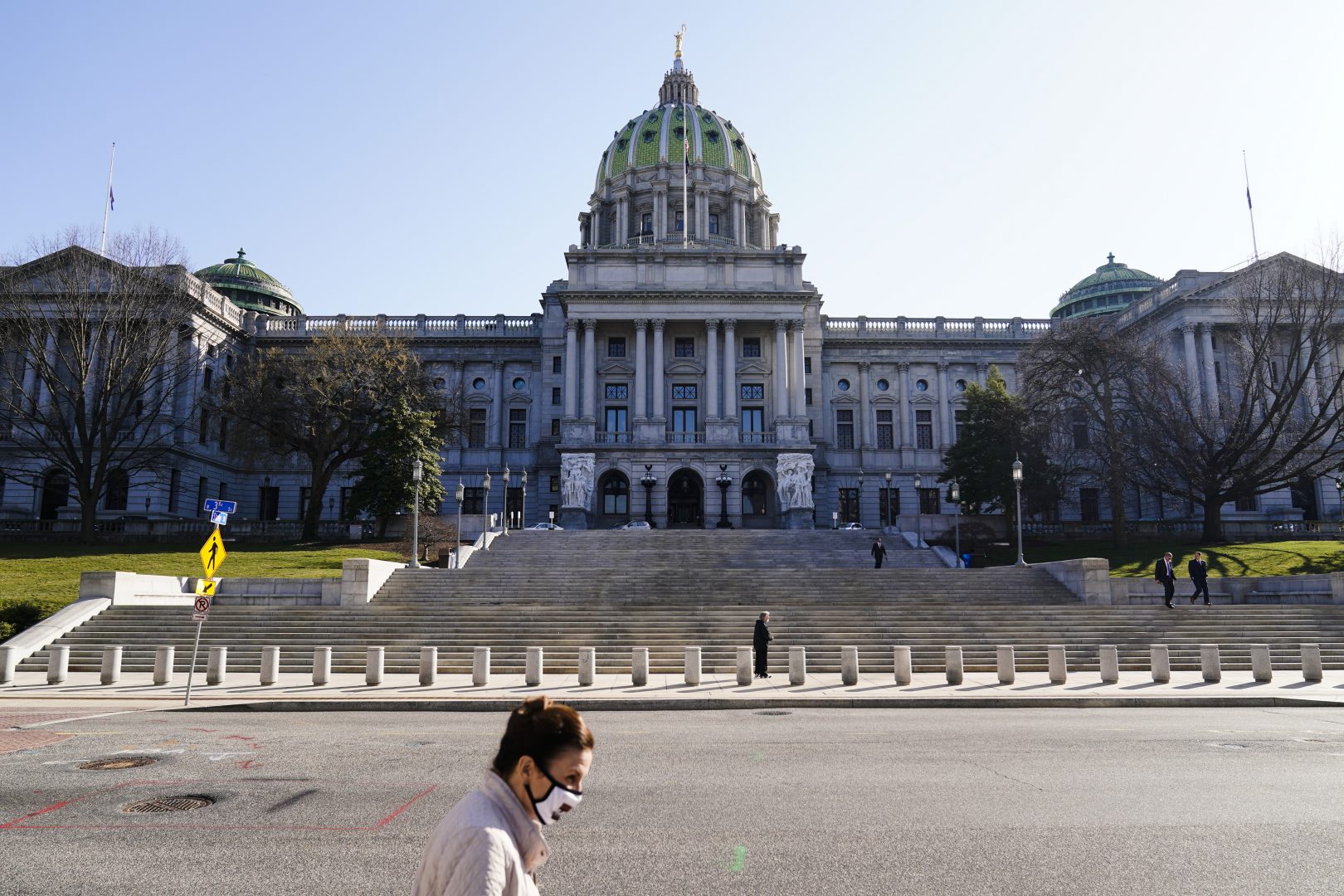 A pedestrian walks past the Pennsylvania Capitol in Harrisburg, Pa., Monday, March 22, 2021.
