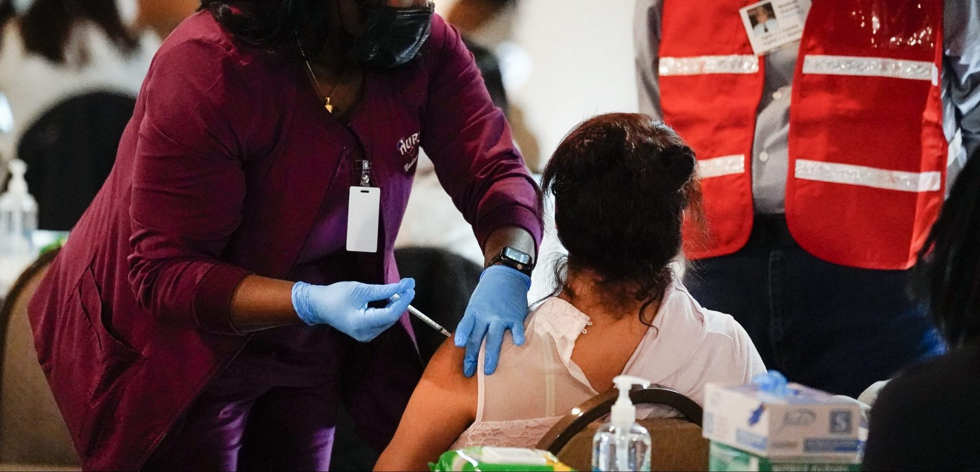 A health worker administers a dose of a Pfizer COVID-19 vaccine during a vaccination clinic at the Grand Yesha Ballroom in Philadelphia, Wednesday, March 17, 2021.
