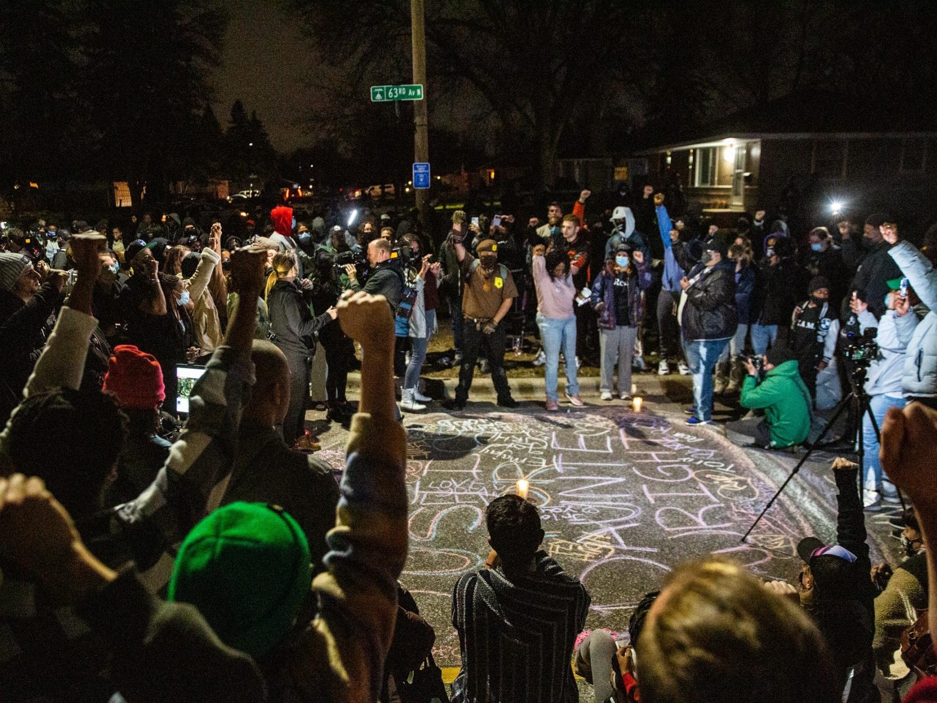 Protesters put their fists in the air in solidarity with the family of Daunte Brooks, who was killed nearby in a traffic stop with a Brooklyn Center police officer, in Brooklyn Center, Minn., on Sunday, April 11, 2021.