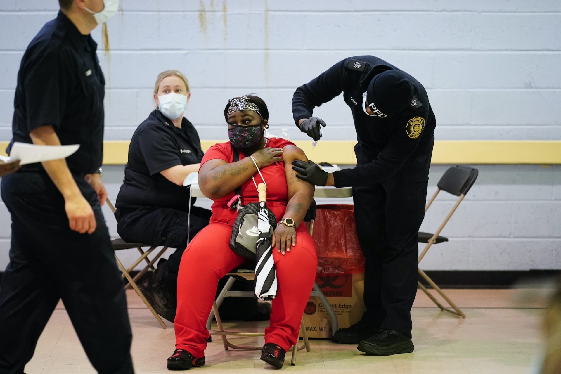 A member of the Philadelphia Fire Department administers the Johnson & Johnson COVID-19 vaccine to a woman at a vaccination site setup at a Salvation Army location in Philadelphia, Friday, March 26, 2021.