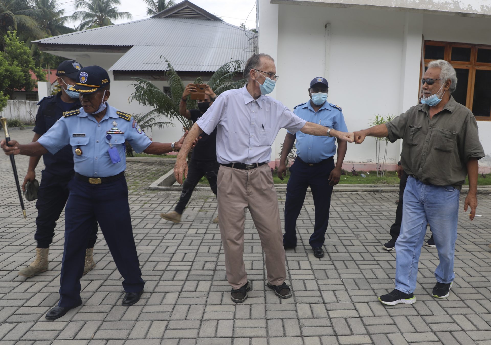 Xanana Gusmao, right, former East Timorese president and prime minister, gives a fist bump to Richard Daschbach, center, a defrocked priest originally from Pennsylvania accused of child abuse, after a hearing at a courthouse in Oecusse, East Timor, on Tuesday, Feb. 23, 2021.