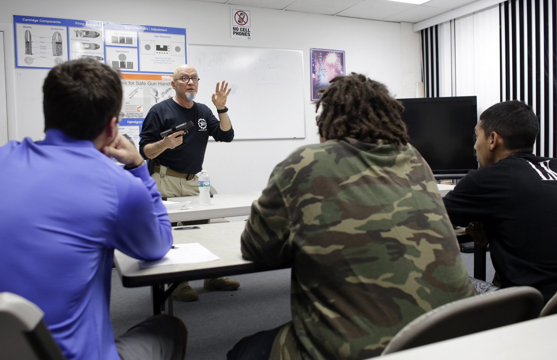 In this Jan. 5, 2016 file photo, Mike Weinstein, director of training and security at the National Armory gun store and gun range, shows how to safely fire a Glock 9mm handgun during a concealed weapons permit class, in Pompano Beach, Fla.