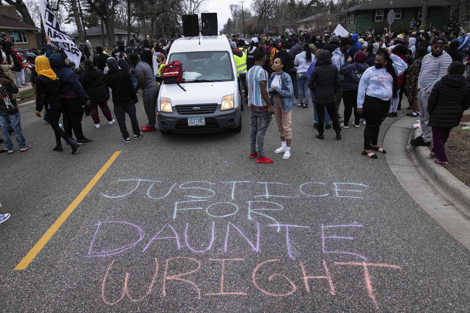People gather in protest, Sunday, April 11, 2021, in Brooklyn Center, Minn. The family of Daunte Wright, 20, told a crowd that he was shot by police Sunday before getting back into his car and driving away, then crashing the vehicle several blocks away. The family said Wright was later pronounced dead.