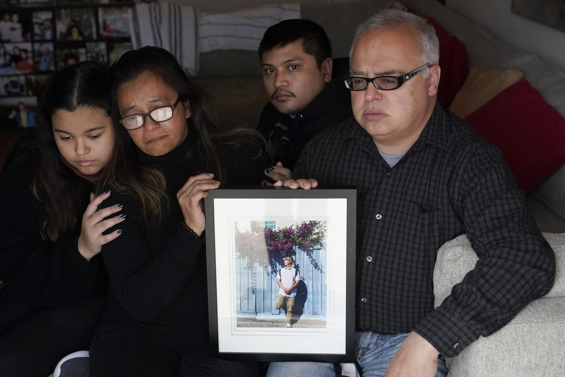 Cassandra Quinto-Collins, second from left, holds a photo of her son, Angelo Quinto, while sitting with daughter Bella Collins, left, son Andrei Quinto, center, and husband Robert Collins during an interview in Antioch, Calif., Tuesday, March 16, 2021.