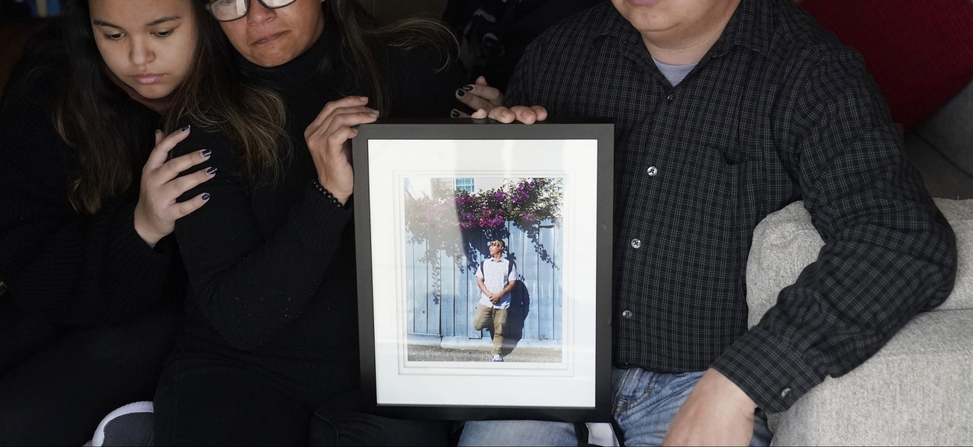 Cassandra Quinto-Collins, second from left, holds a photo of her son, Angelo Quinto, while sitting with daughter Bella Collins, left, son Andrei Quinto, center, and husband Robert Collins during an interview in Antioch, Calif., Tuesday, March 16, 2021. Angelo Quinto died three days after being restrained on Dec. 23, 2020, in police custody while having a mental health crisis. Lawmakers in several states are proposing legislation that would require more training for police in how to interact with someone in a mental crisis following some high-profile deaths. 
