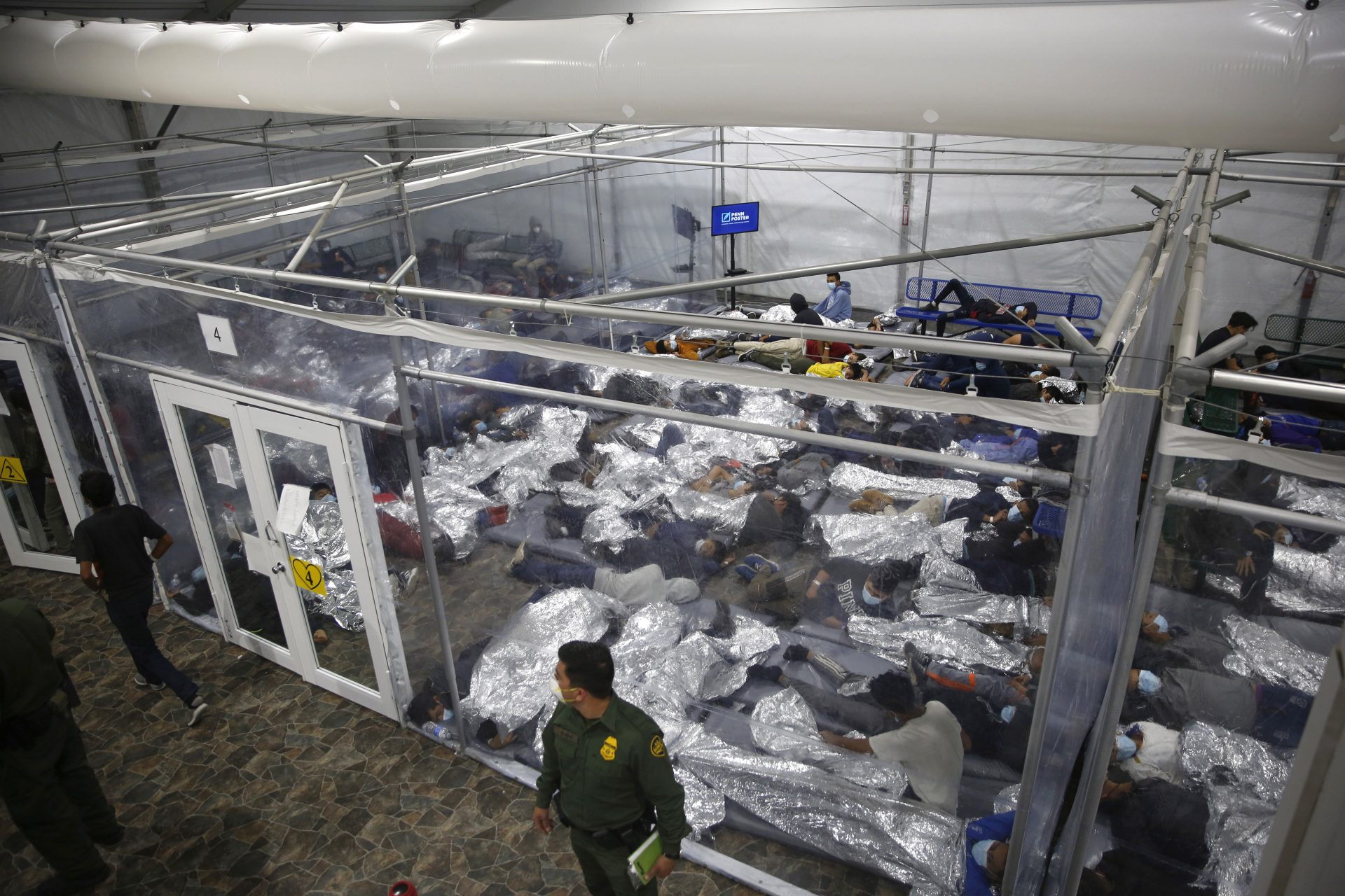 In this March 30, 2021, file photo, young minors lie inside a pod at the Donna Department of Homeland Security holding facility, the main detention center for unaccompanied children in the Rio Grande Valley run by U.S. Customs and Border Protection (CBP), in Donna, Texas.