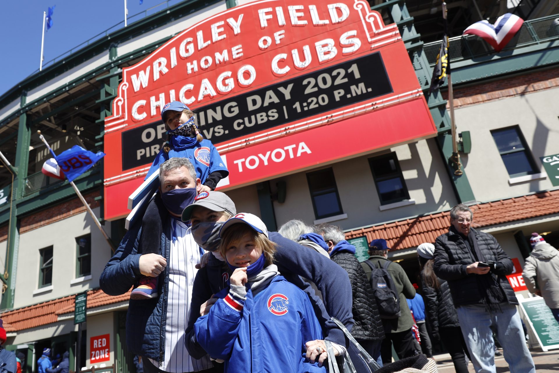 A family poses for a photo outside of Wrigley Field on the opening day baseball game between the Chicago Cubs and the Pittsburgh Pirates, Thursday, April 1, 2021, in Chicago.