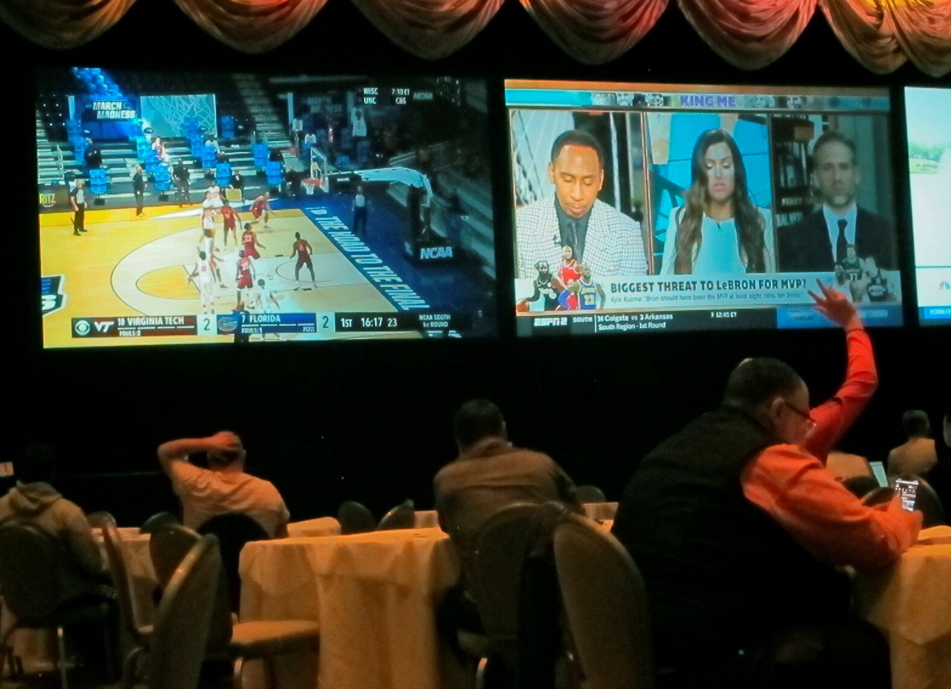 Customers watch a game in the NCAA basketball March Madness tournament on Friday March 19, 2021 at the Borgata casino in Atlantic City NJ. Last year, it was March sadness as the NCAA college basketball tournament got canceled days before it was supposed to start, due to the coronavirus.
