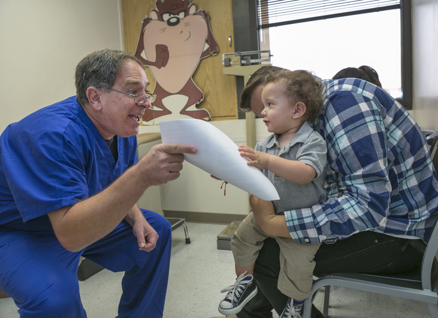 Pediatrician Charles Goodman, left, explains to Frank Fierro, the father of 1 year-old Cameron Fierro, the need of getting the measles-mumps-rubella vaccine, or MMR vaccine at his practice in Northridge, Calif., Thursday, Jan. 29, 2015. Some doctors are adamant about not accepting patients who don't believe in vaccinations, with some saying they don't want to be responsible for someone's death from an illness that was preventable. Others warn that refusing treatment to such people will just send them into the arms of quacks.