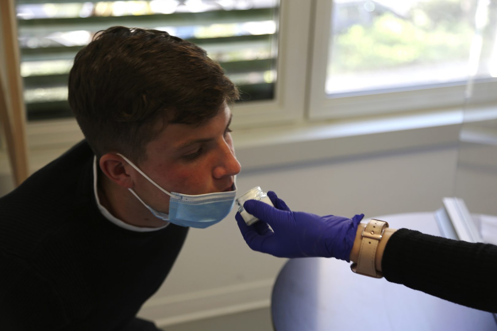 Evan Cesa, a patient, smells a small pot of fragrance during tests in a clinic in Nice, France, on Monday, Feb. 8, 2021, to help determine how his sense of smell and taste have been degraded since he contracted COVID-19 in September 2020.