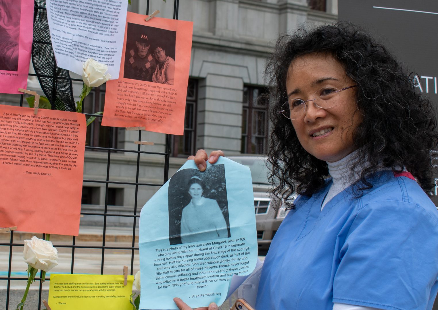 Registered nurse Mary Lou Arocena holds a photo of a nurse who died from COVID-19. Arocena, 60, worked as nurse for 35 years before retiring last year, facing burnout from the stress of the job.  