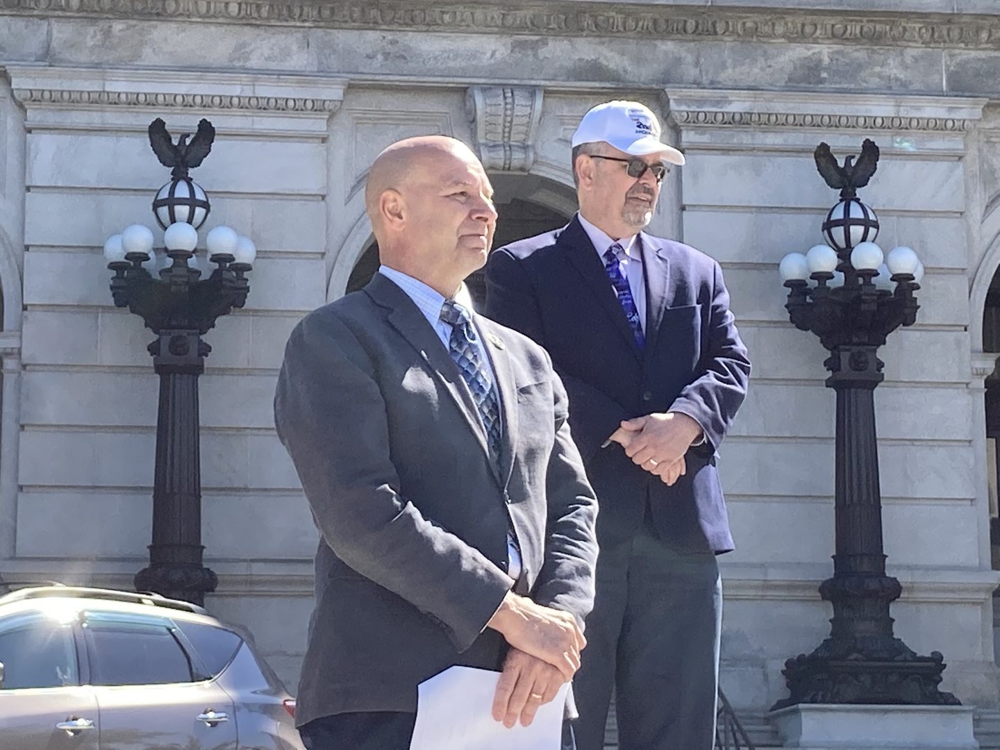 At left, state Sen. Doug Mastriano (R-Adams) watches as a speaker gives remarks at a rally supporting a bill aiming to make new federal firearm regulations enacted after Dec. 2020 unenforceable in Pennsylvania on May 12, 2021. At right in the background, state Sen. Cris Dush (R-Cameron).