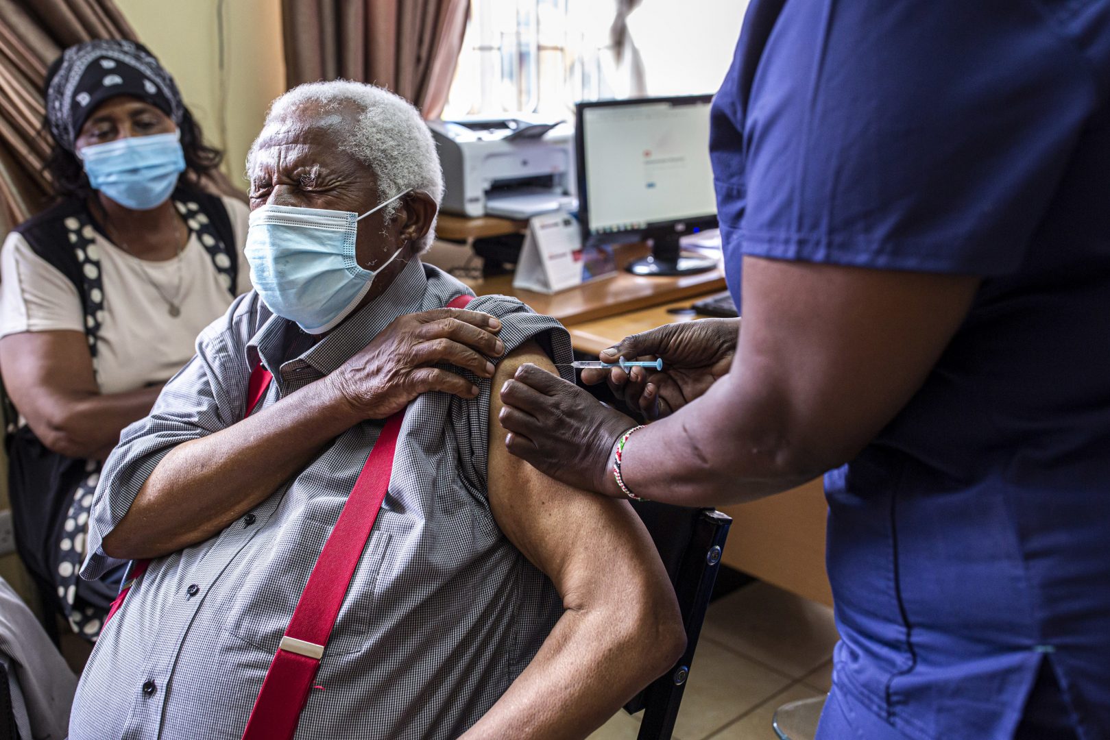 An elderly resident receives a dose of the Covishield Covid-19 vaccine, developed by AstraZeneca Plc and the University of Oxford and manufactured by Serum Institute of India Ltd., at Thika Level 5 Hospital in Thika, Kenya, on Tuesday, March 30, 2021. Kenyan hospitals are grappling with record numbers of critical-care patients, stretching a system that was inadequate even before the outbreak of Covid-19. Photographer: Patrick Meinhardt/Bloomberg via Getty Images