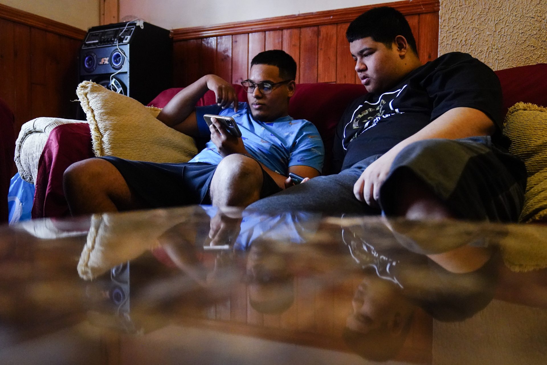 Mino Zuniga Gonzales, 19, left, and his brother Erick Zuniga Gonzales, 17, look at a smart phone in the Kensington section of Philadelphia, Sunday, May 16, 2021.