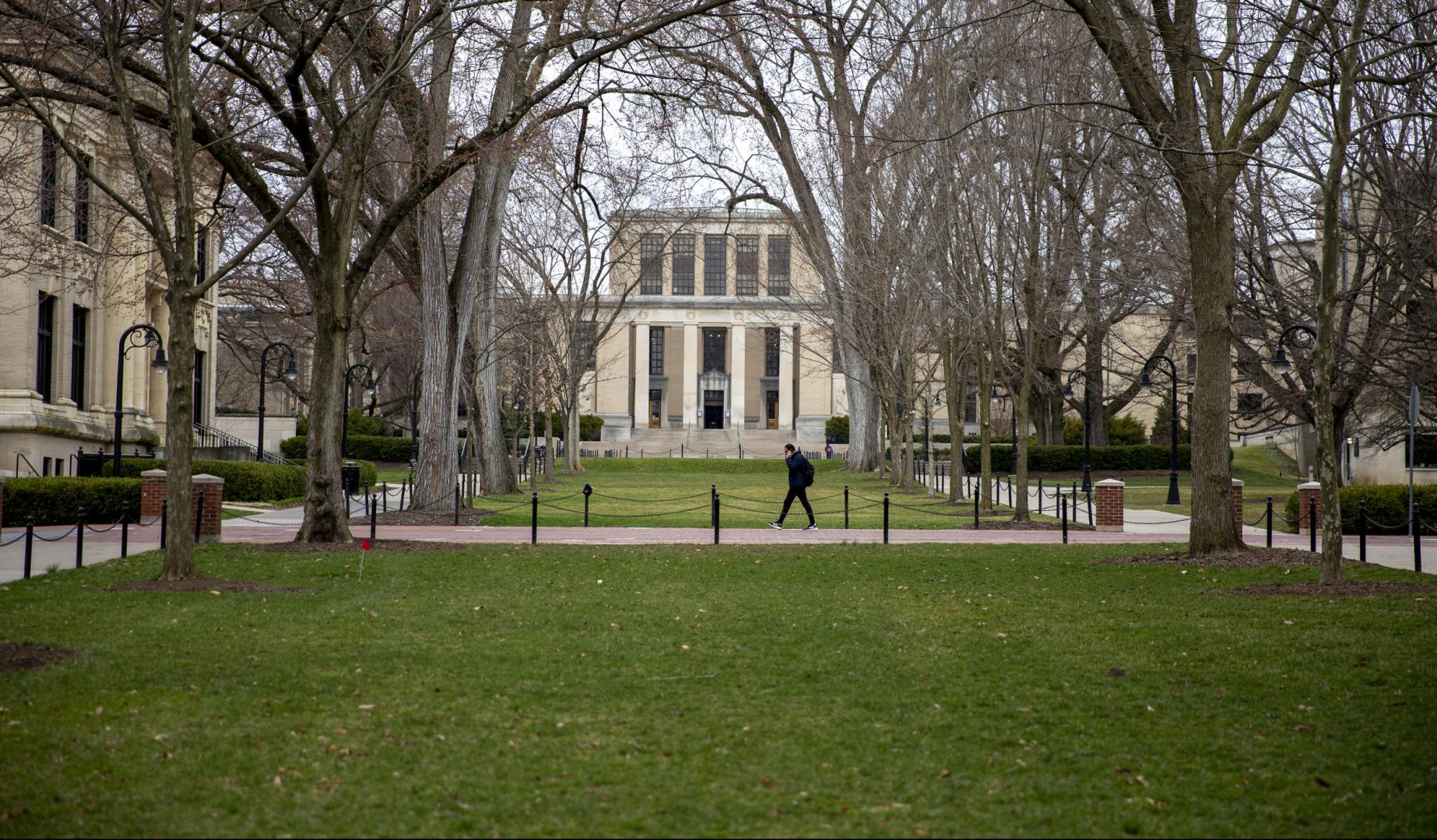 A student walks across the Penn State campus.