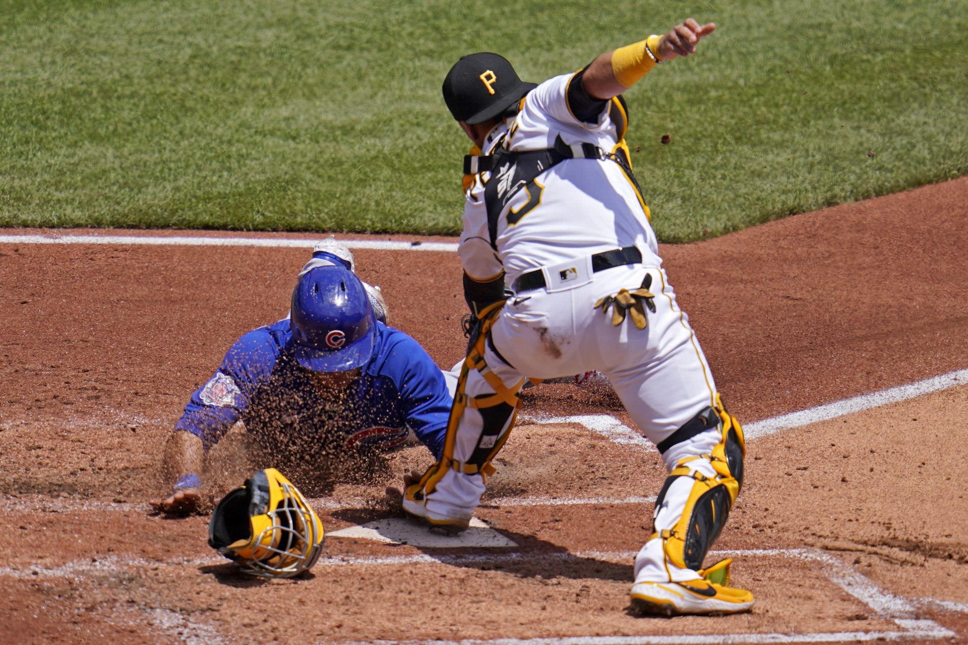 Chicago Cubs' Willson Contreras, left, scores ahead of the tag attempt by Pittsburgh Pirates catcher Michael Perez during the third inning of a baseball game in Pittsburgh, Thursday, May 27, 2021. Contreras scored on a fielder's choice by Javier Baez.