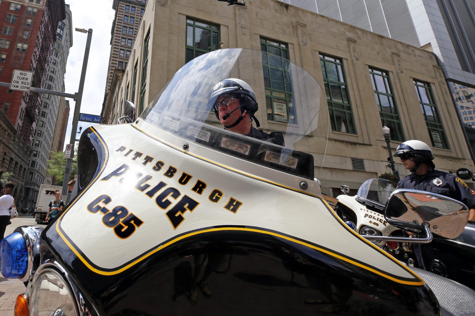 Pittsburgh Police motorcycle officers watch as a rally and protest over the police shooting of Antwon Rose II blocks the intersection of Fifth Ave. and Wood Street in downtown Pittsburgh during the lunch hour on Friday, July 27, 2018.