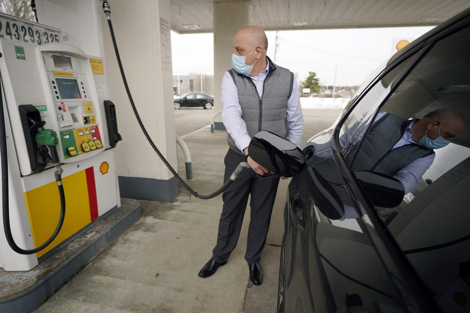 In this Thursday, Feb. 18, 2021 file photo, Jeremy Heskett, of Boston, pumps gasoline at a Shell gas station, in Westwood, Mass. 