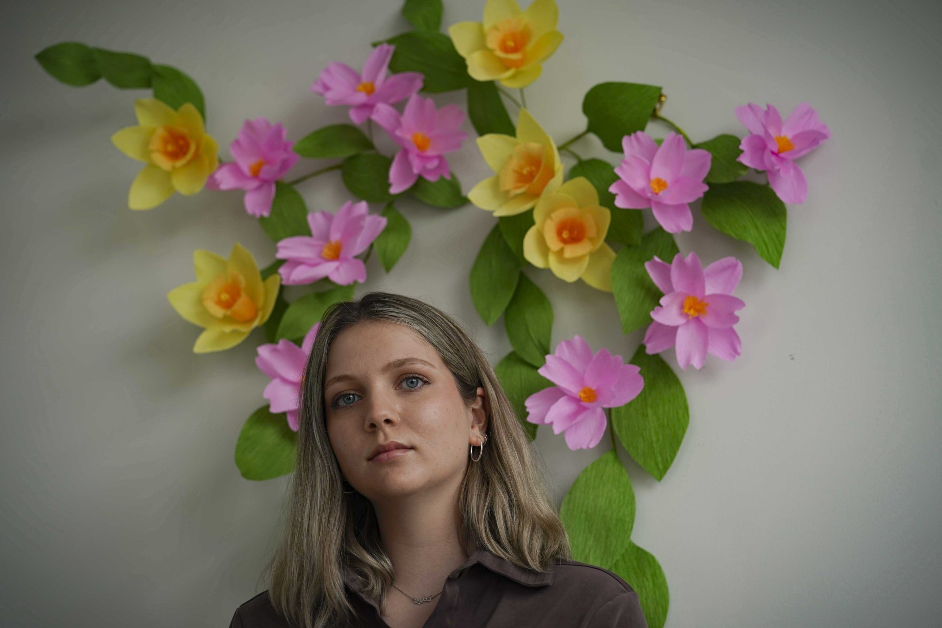 Artist and puppeteer Katayoun Amir-Aslani stands for a portrait next to her floral art creation in New York on Friday, April 9, 2021. The artwork signals "re-birth and new beginnings," said Amir-Aslani. Balance, harmony and wholeness. That's how I feel now." Amir-Aslani left Gettysburg College after a sexual assault in the spring of 2014.