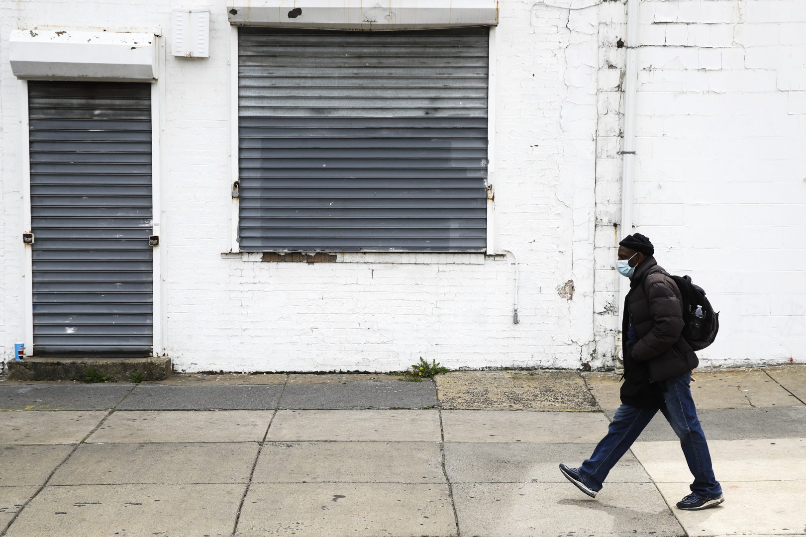 FILE PHOTO: A person walks past a shuttered business in Philadelphia, Thursday, April 23, 2020.