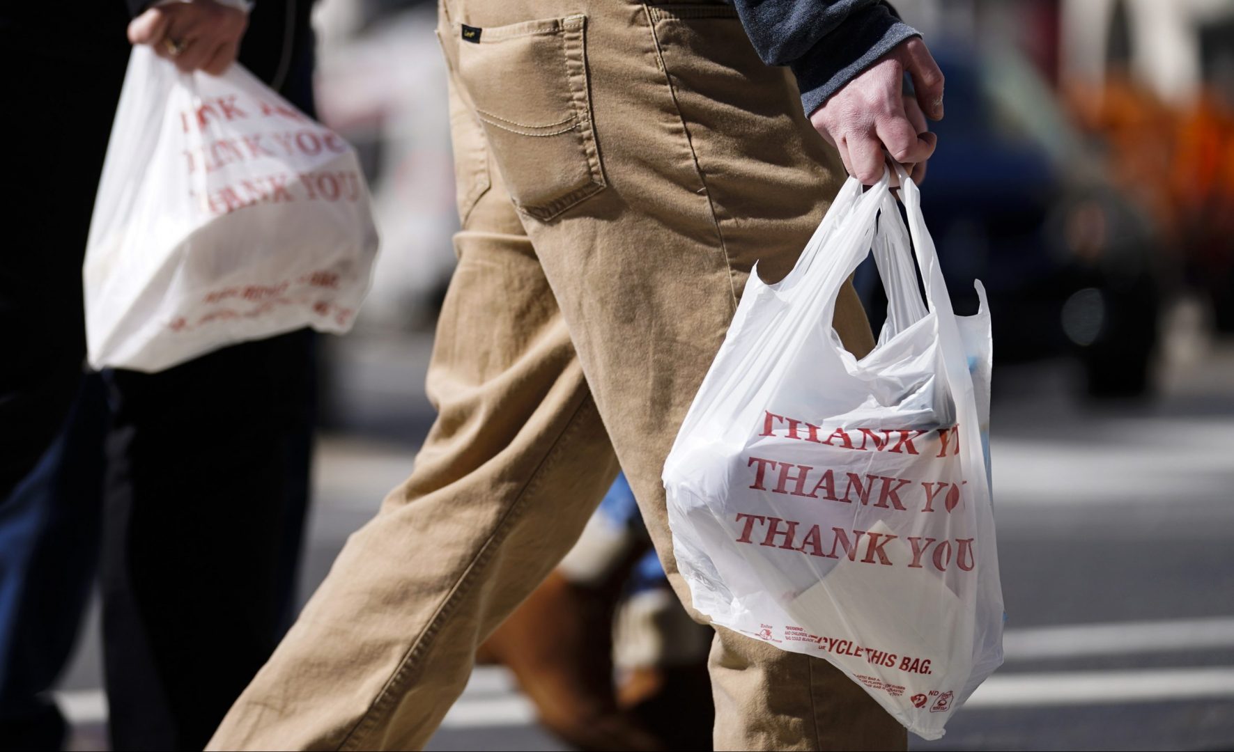 Pedestrians carry plastic bags in Philadelphia, Wednesday, March 3, 2021. Philadelphia and three other municipalities in Pennsylvania sued the state over what they say was a covert abuse of legislative power to temporarily halt local bans or taxes on plastic bags handed out to customers by retailers.