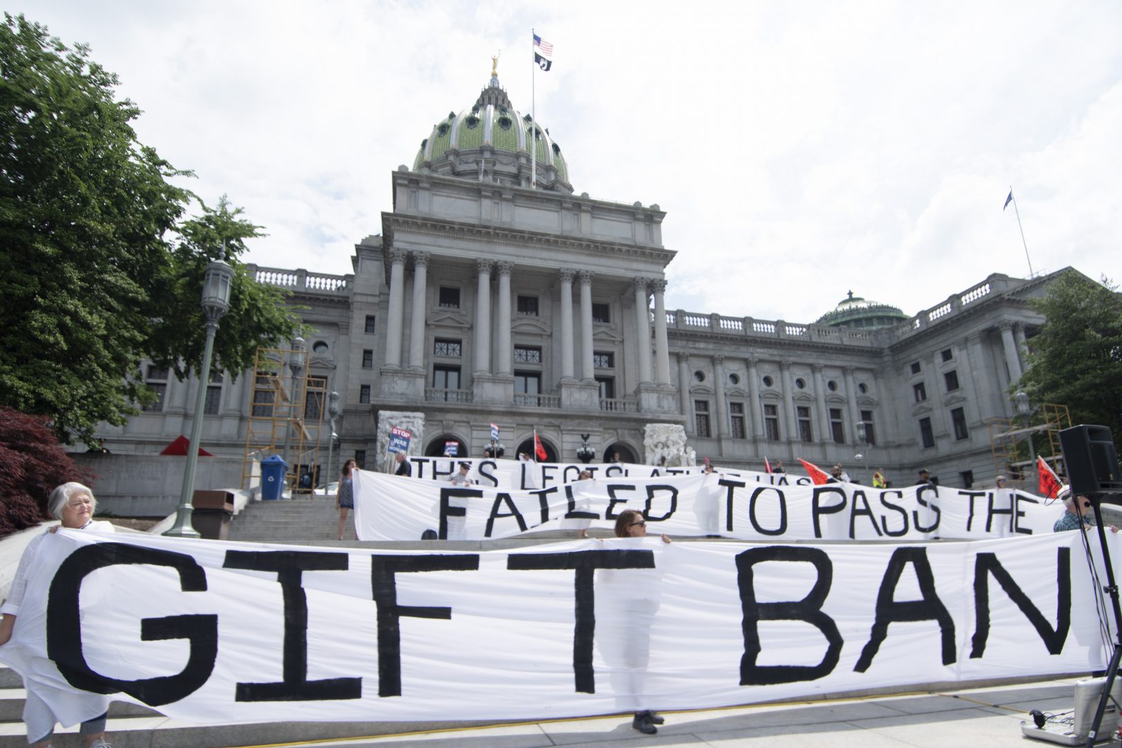 Demonstrators from MarchOnHarrisburg stand outside Pennsylvania’s Capitol to press lawmakers to pass legislation banning them from taking gifts from lobbyists and others aiming to influence them, Wednesday, June 9, 2021, in Harrisburg, Pa. The Pennsylvania Legislature does not limit how much lawmakers can accept from lobbyists and others seeking to influence them.