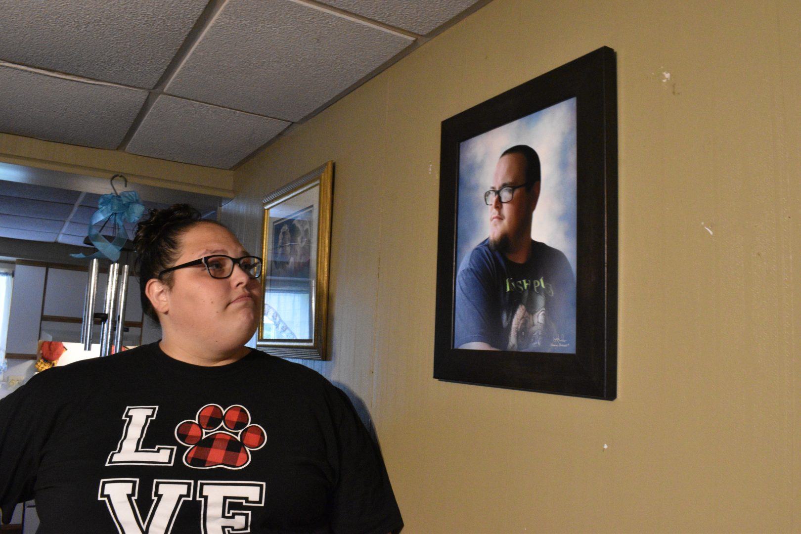 Stephanie Rimel looks at a photo of her younger brother, Kyle Dixon, inside the house Kyle shared with his dad. 