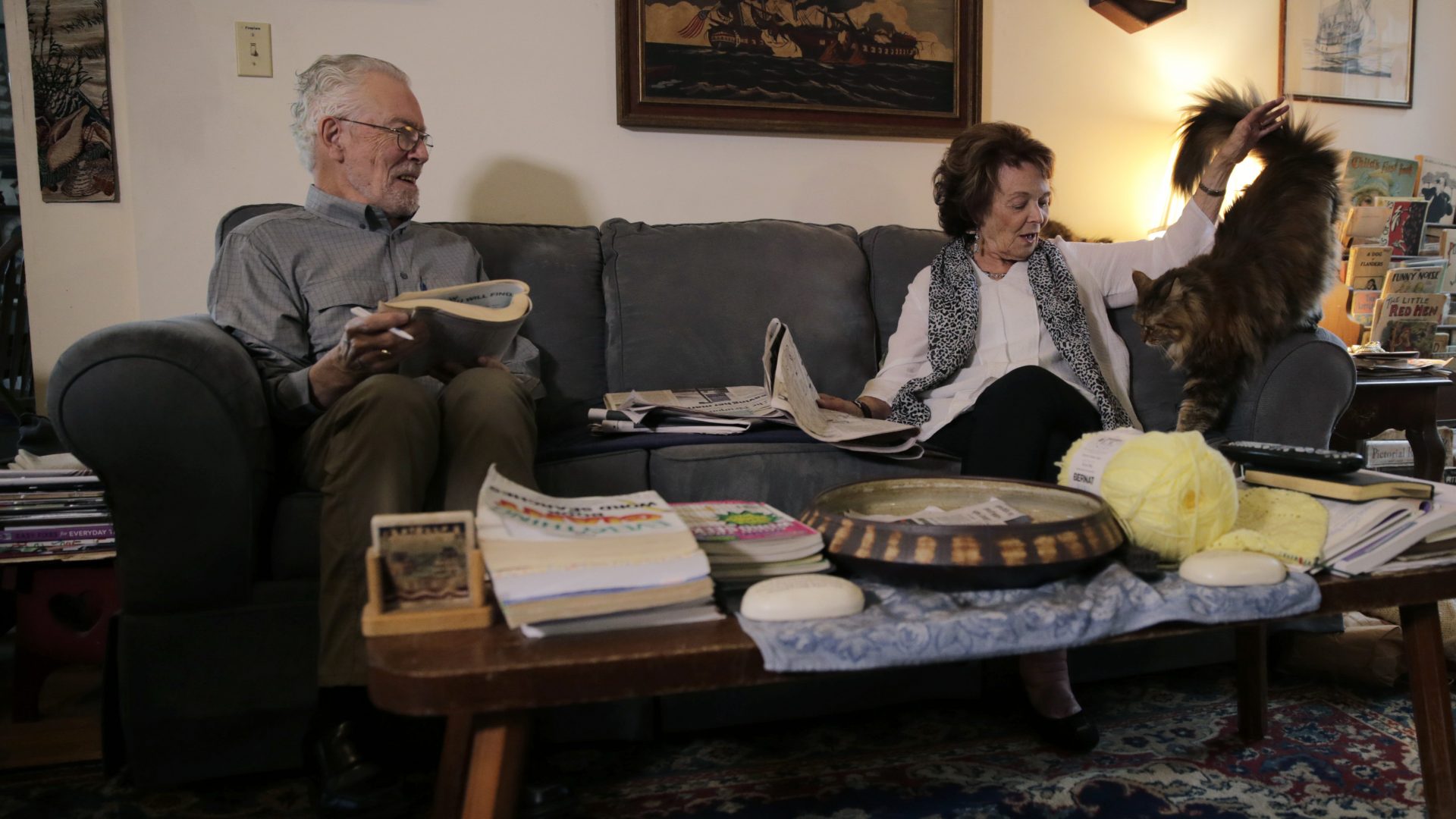 n this Nov. 22, 2019, photo, Charles Flagg, who is stricken with Alzheimer's disease, works on a word puzzle while sitting with his wife Cynthia, right, at their home in Jamestown, R.I.