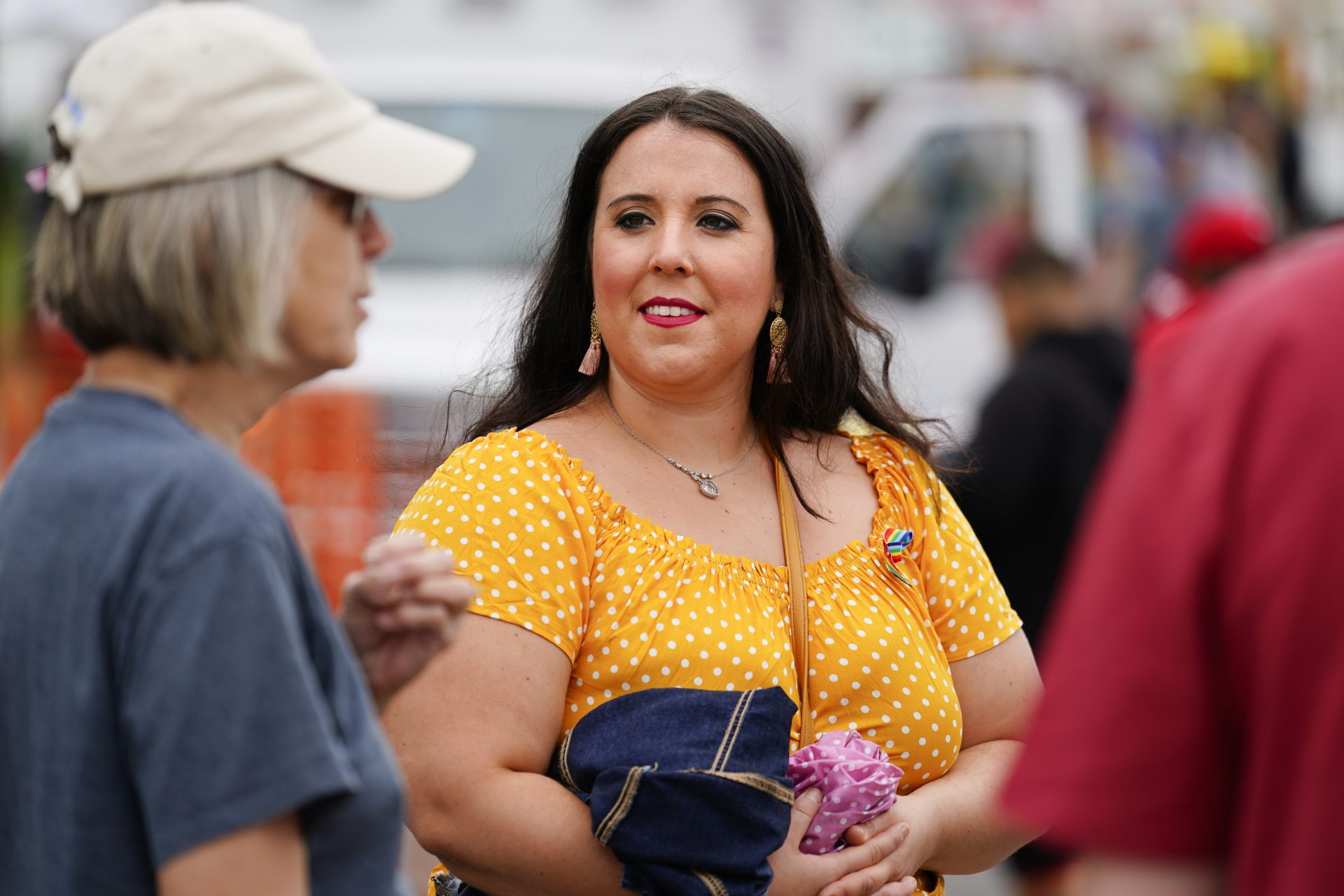 Alicia Duque, a 35-year-old mother of three and volunteer organizer for the progressive group, Action Together listens to Claudia Glennan at the Edwardsville Pierogi Festival in Edwardsville, Pa., Friday, June 11, 2021.