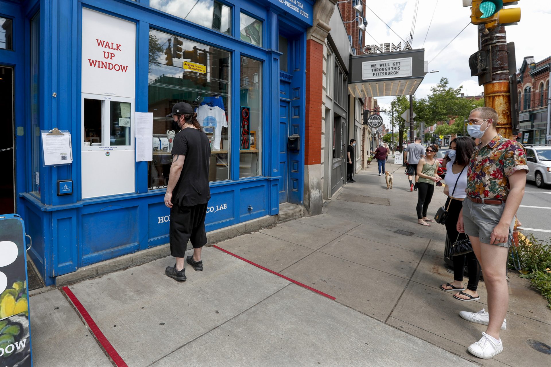 People wait for a take-out order at a restaurant along Butler Street in Pittsburgh's Lawrenceville neighborhood as counties in southwestern Pennsylvania join northwestern and the north central regions with more relaxed COVID-19 prevention restrictions, Friday, May 15, 2020, in Pittsburgh.