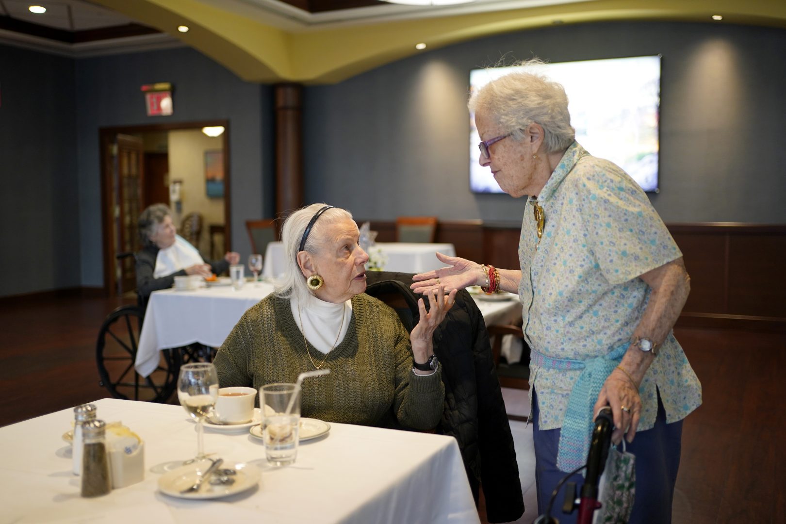 FILE PHOTO: Ita Aber, right, stops by the table of her old friend Rita Shliselberg after she finished dinner at RiverWalk, an independent senior housing facility, in New York, Thursday, April 1, 2021. 