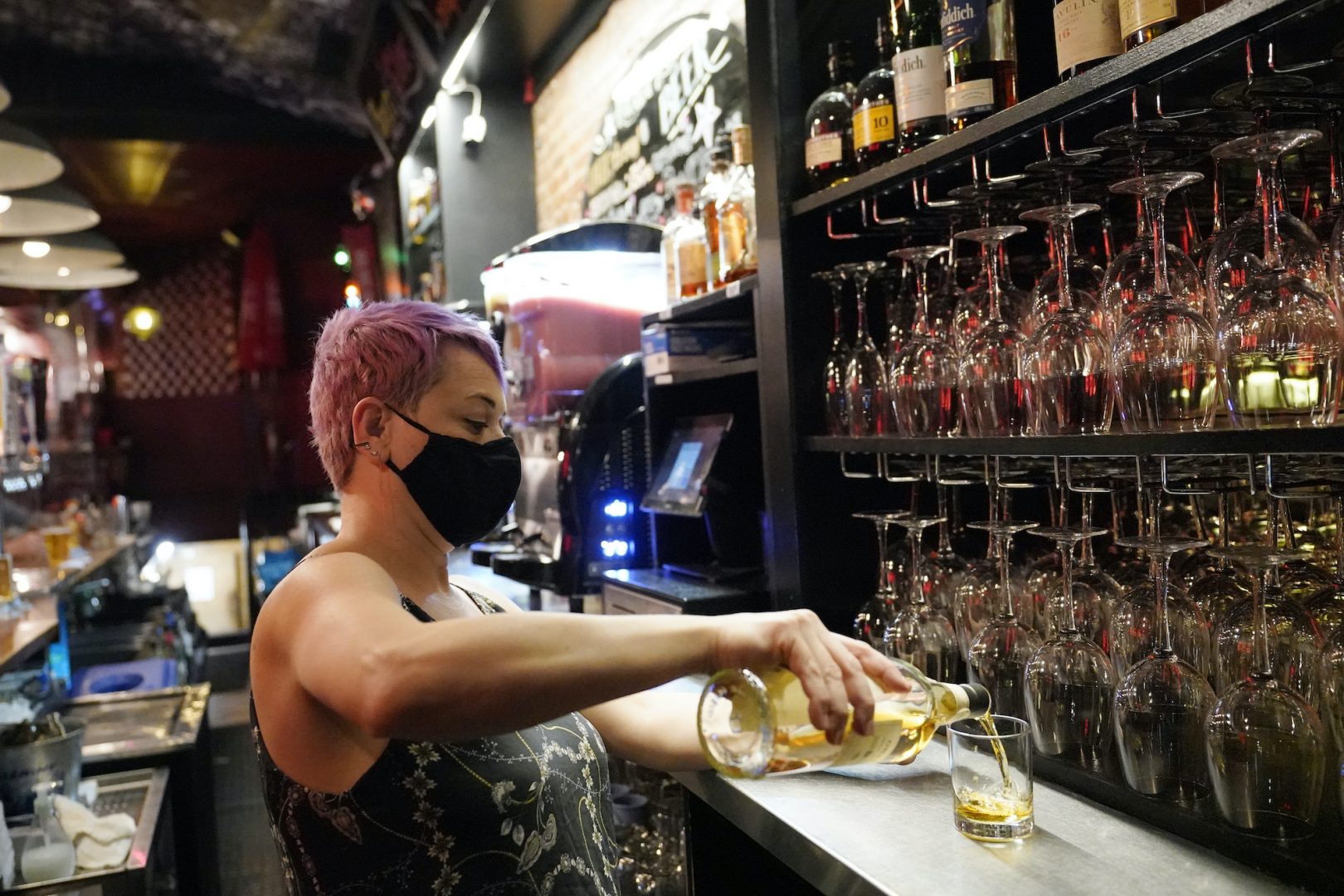 Erin Bellard pours a drink for a customer at her bar on Manhattan's Upper West Side, Monday, May 17, 2021, in New York.