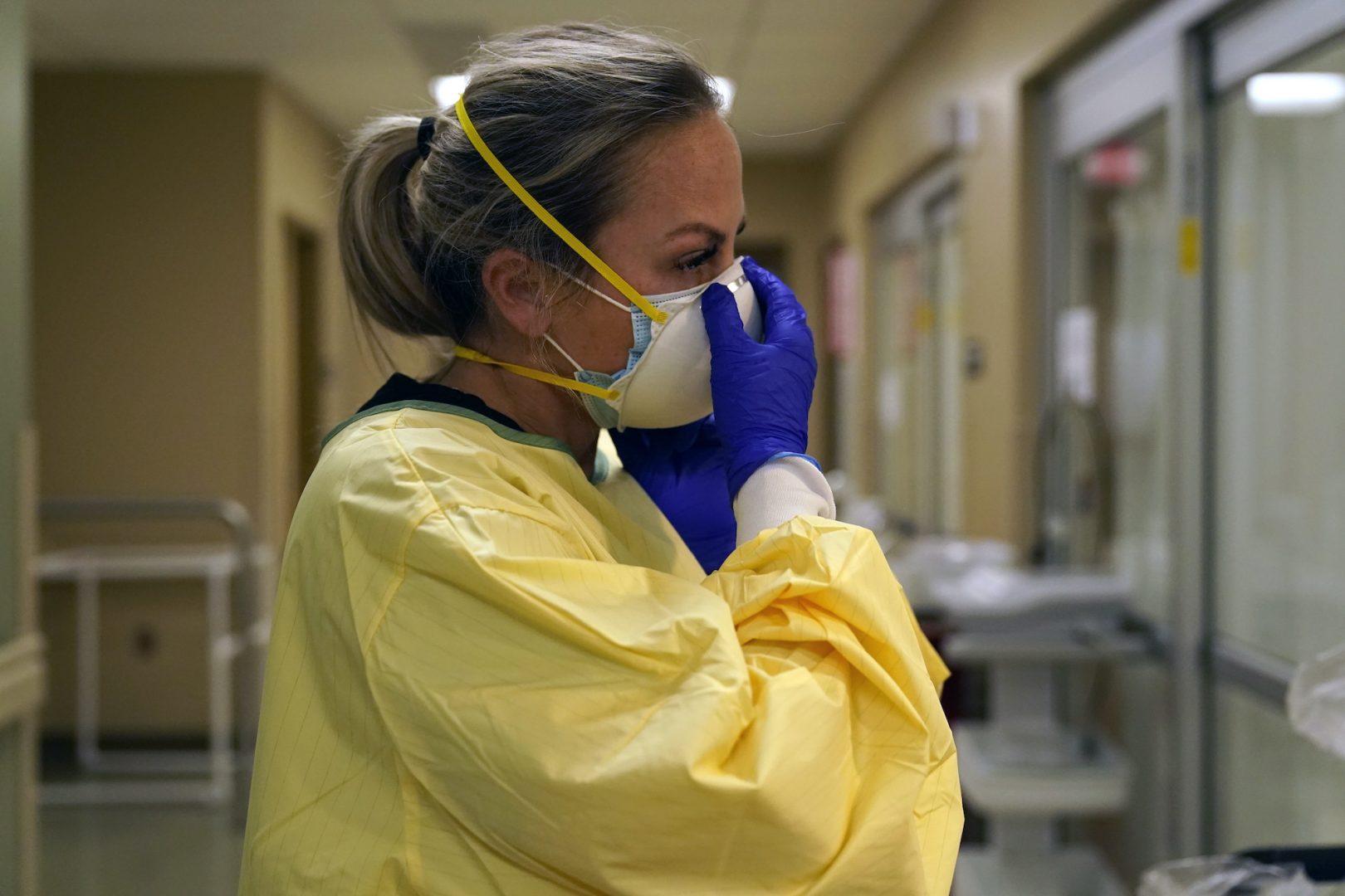 Registered nurse Chrissie Burkhiser puts on personal protective equipment as she prepares to treat a COVID-19 patient in the in the emergency room at Scotland County Hospital Tuesday, Nov. 24, 2020, in Memphis, Mo. The tiny hospital in rural northeast Missouri is seeing an alarming increase in coronavirus cases.