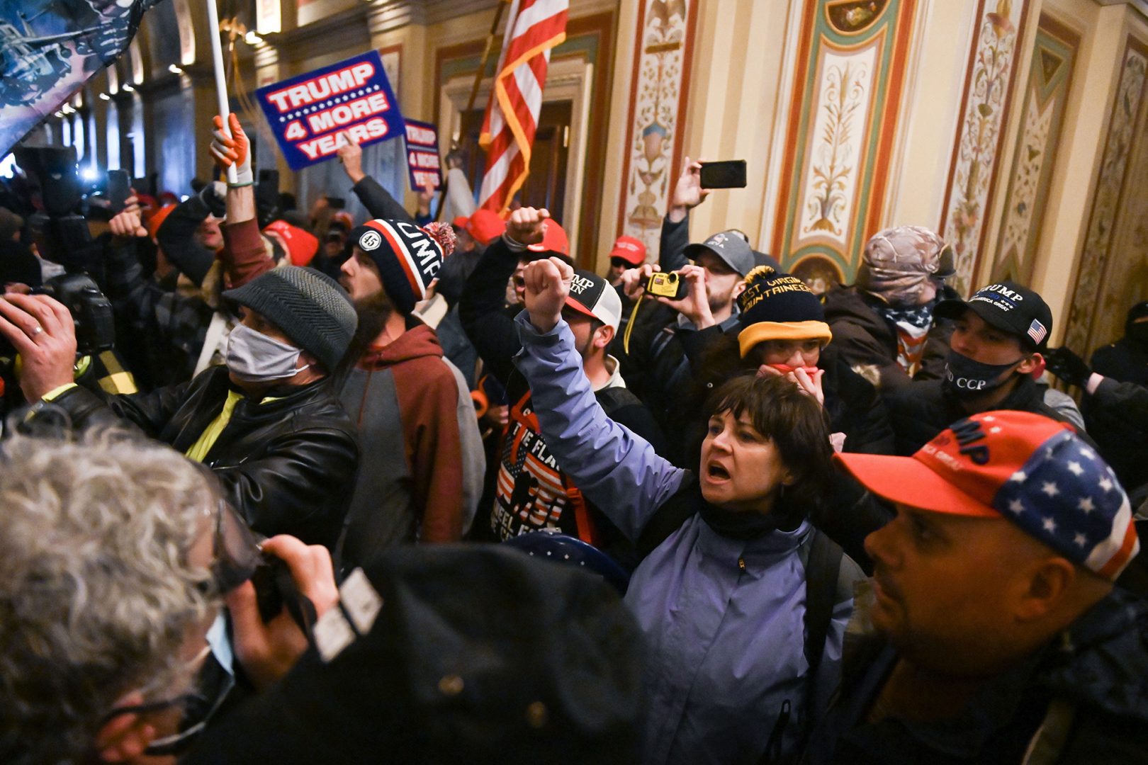 A mob breached security and stormed inside the U.S. Capitol on Jan. 6. The woman in blue with her fist raised was later identified as Suzanne Ianni.