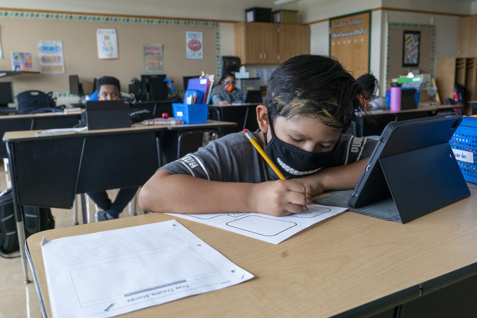 FILE PHOTO: A student wears a face mask while doing work at his desk at the Post Road Elementary School, in White Plains, N.Y., in this Thursday, Oct. 1, 2020, file photo.