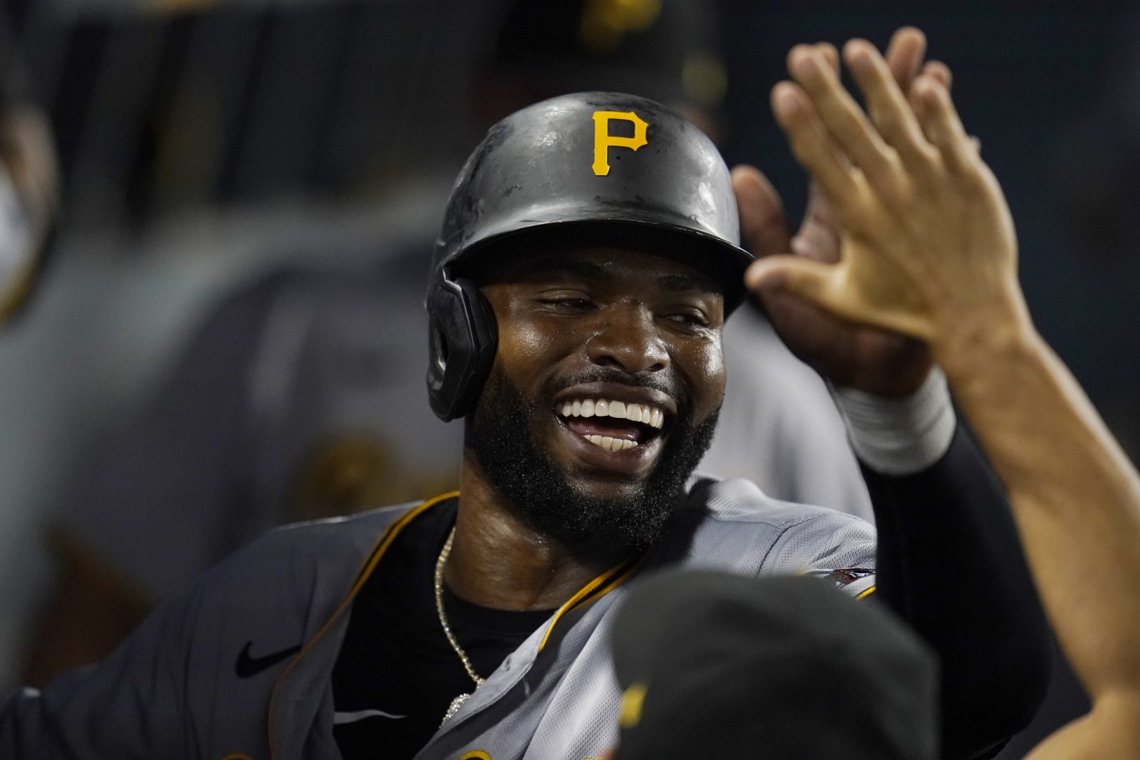 Pittsburgh Pirates' Gregory Polanco (25) is high-fived by teammates in the dugout after scoring a run during the sixth inning of a baseball game against the Los Angeles Dodgers Monday, Aug. 16, 2021, in Los Angeles. (AP Photo/Marcio Jose Sanchez)