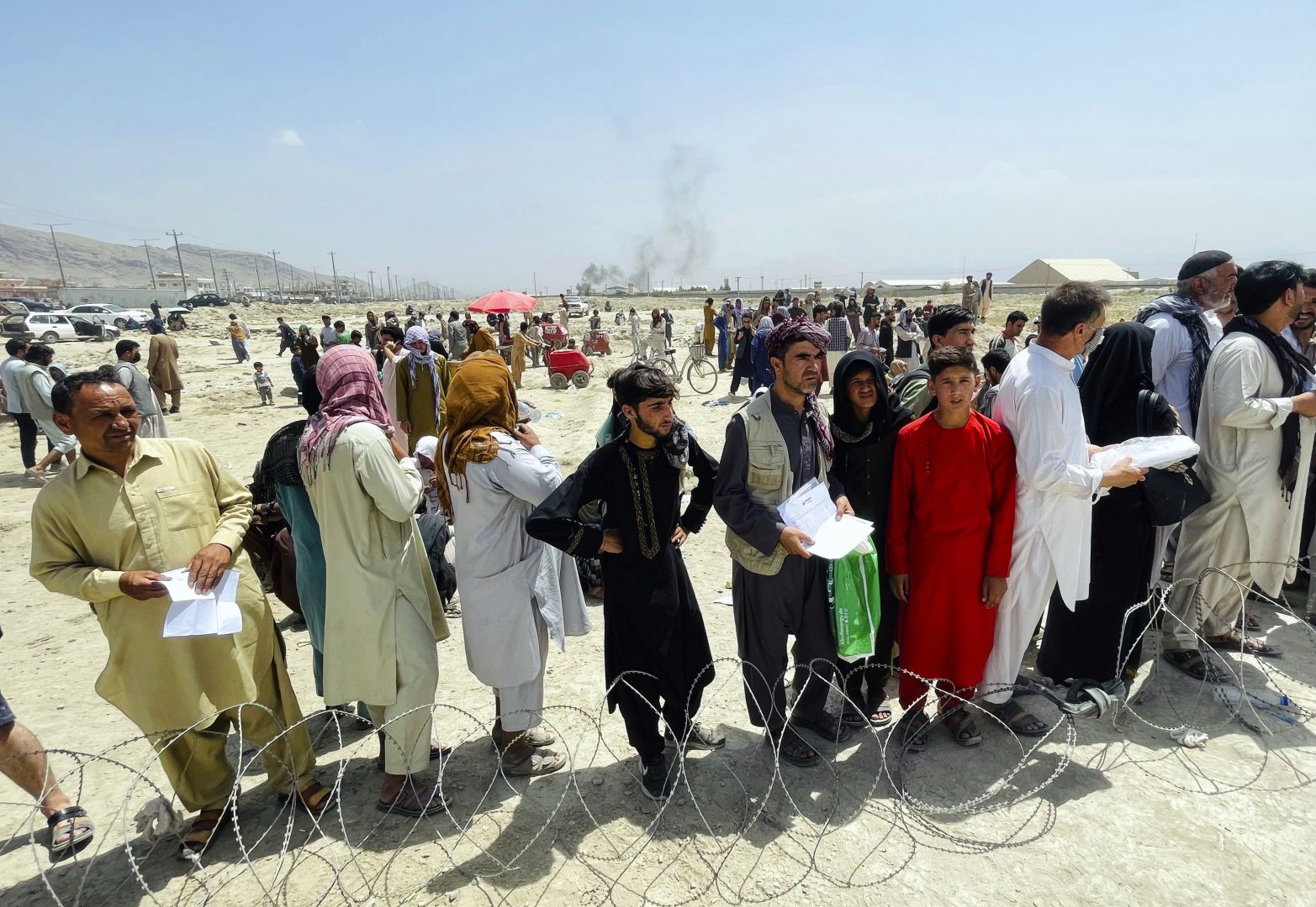 Hundreds of people gather outside the international airport in Kabul, Afghanistan, Tuesday, Aug. 17, 2021. The Taliban declared an “amnesty” across Afghanistan and urged women to join their government Tuesday, seeking to convince a wary population that they have changed a day after deadly chaos gripped the main airport as desperate crowds tried to flee the country.