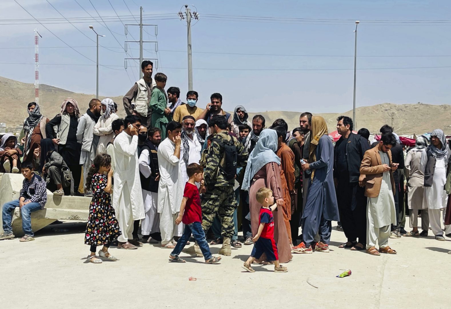 Hundreds of people gather outside the international airport in Kabul, Afghanistan, Tuesday, Aug. 17, 2021. The Taliban declared an “amnesty” across Afghanistan and urged women to join their government Tuesday, seeking to convince a wary population that they have changed a day after deadly chaos gripped the main airport as desperate crowds tried to flee the country.
