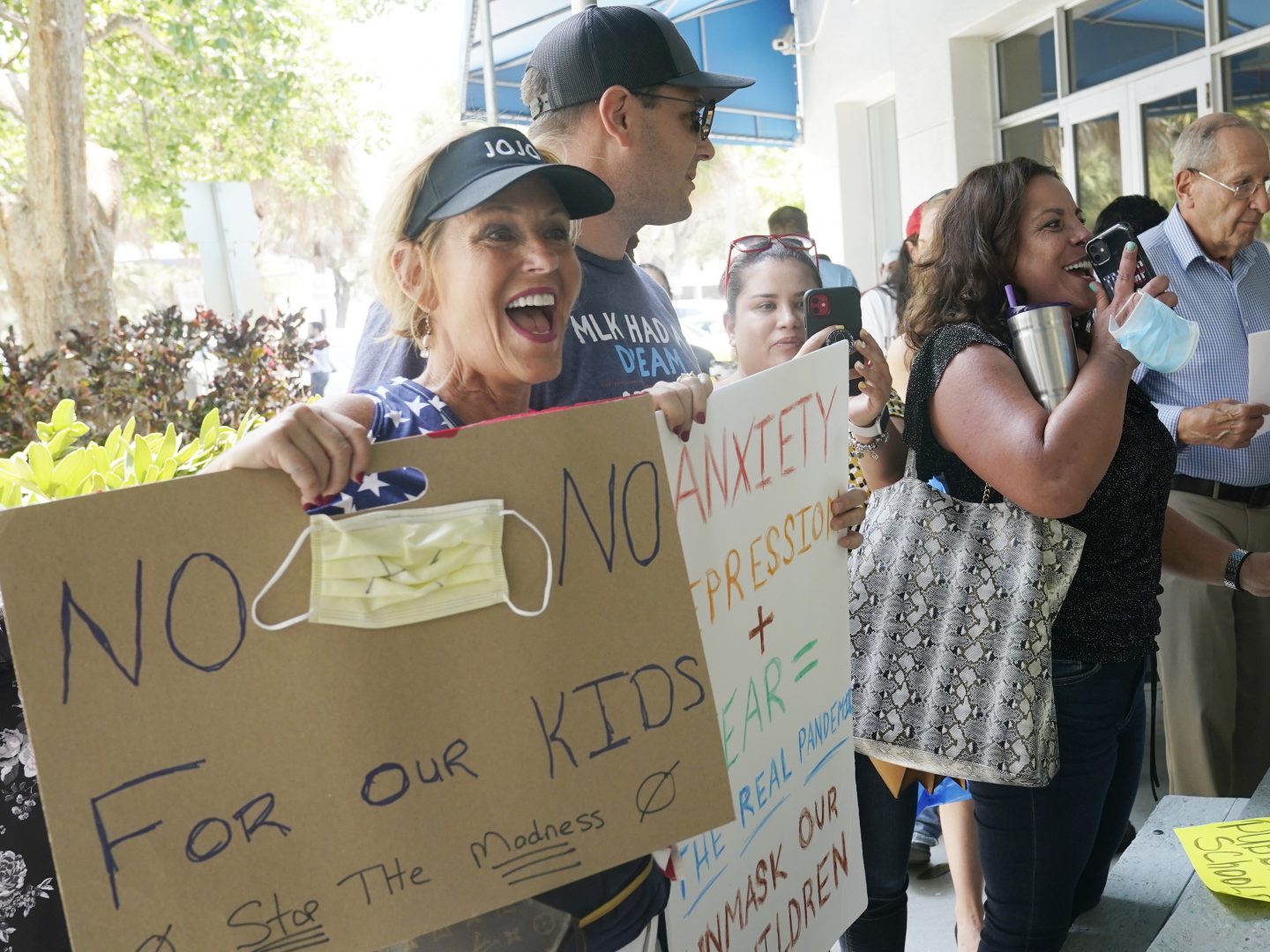 Joann Marcus of Fort Lauderdale, left, cheers as she listens to the Broward School Board's emergency meeting, Wednesday, July 28, 2021, in Fort Lauderdale, Fla. A small but vocal group spoke vehemently against masks, saying their personal rights were being eroded and their children were suffering socially.