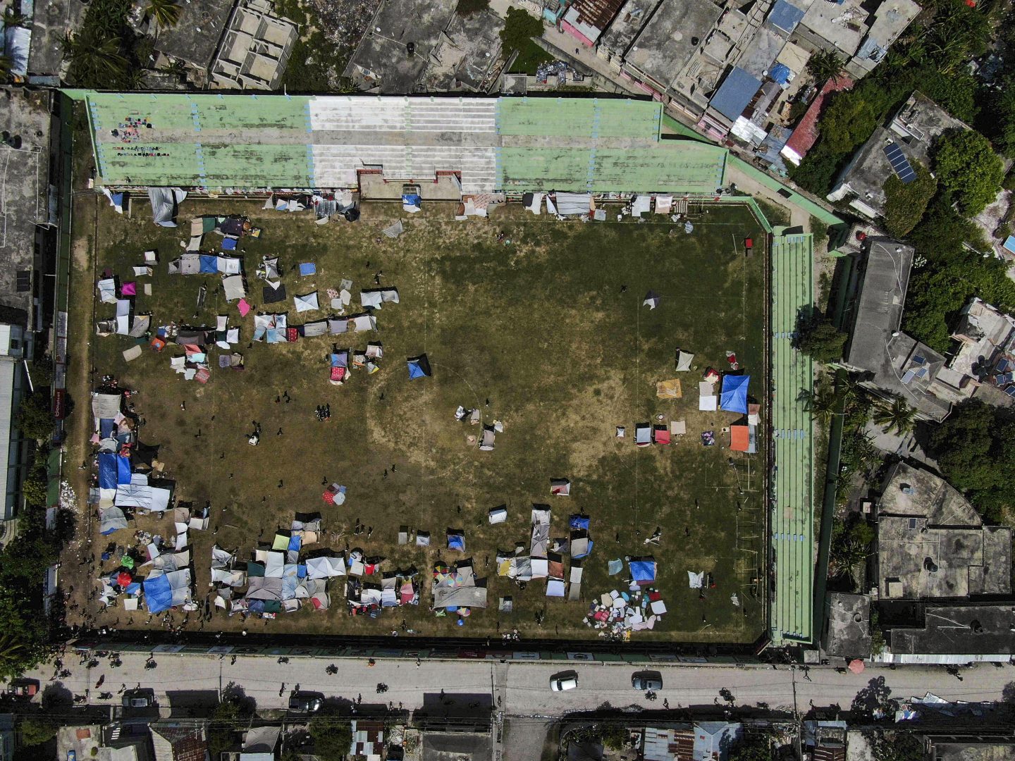 Residents whose homes were damaged during the earthquake campout at a soccer field in Les Cayes, Haiti, Monday, Aug. 16, 2021.